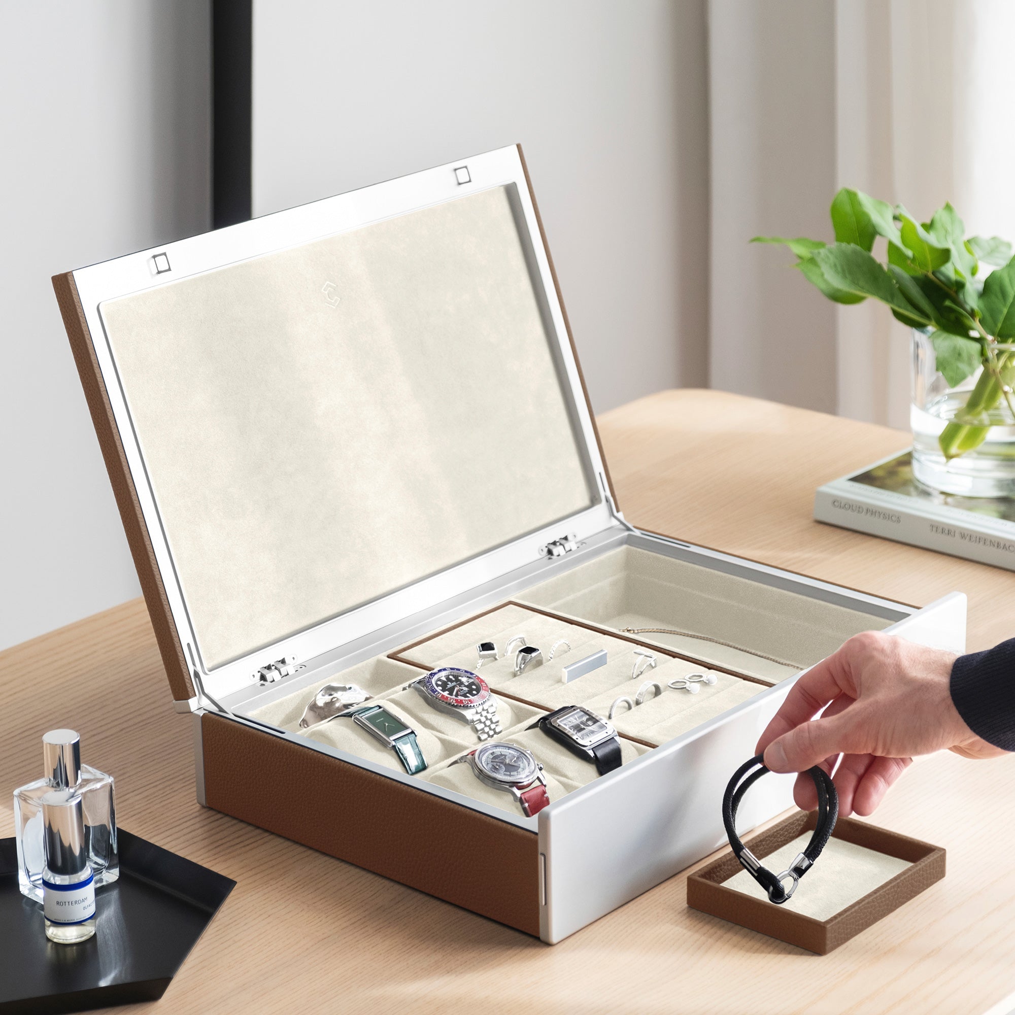 Lifestyle photo of man grabbing bracelet from the jewelry tray of the Taylor 4 Watch and Jewelry box. The jewelry organization and watch storage box is holding 4 luxury watches and a collection of rings, earrings and necklaces.