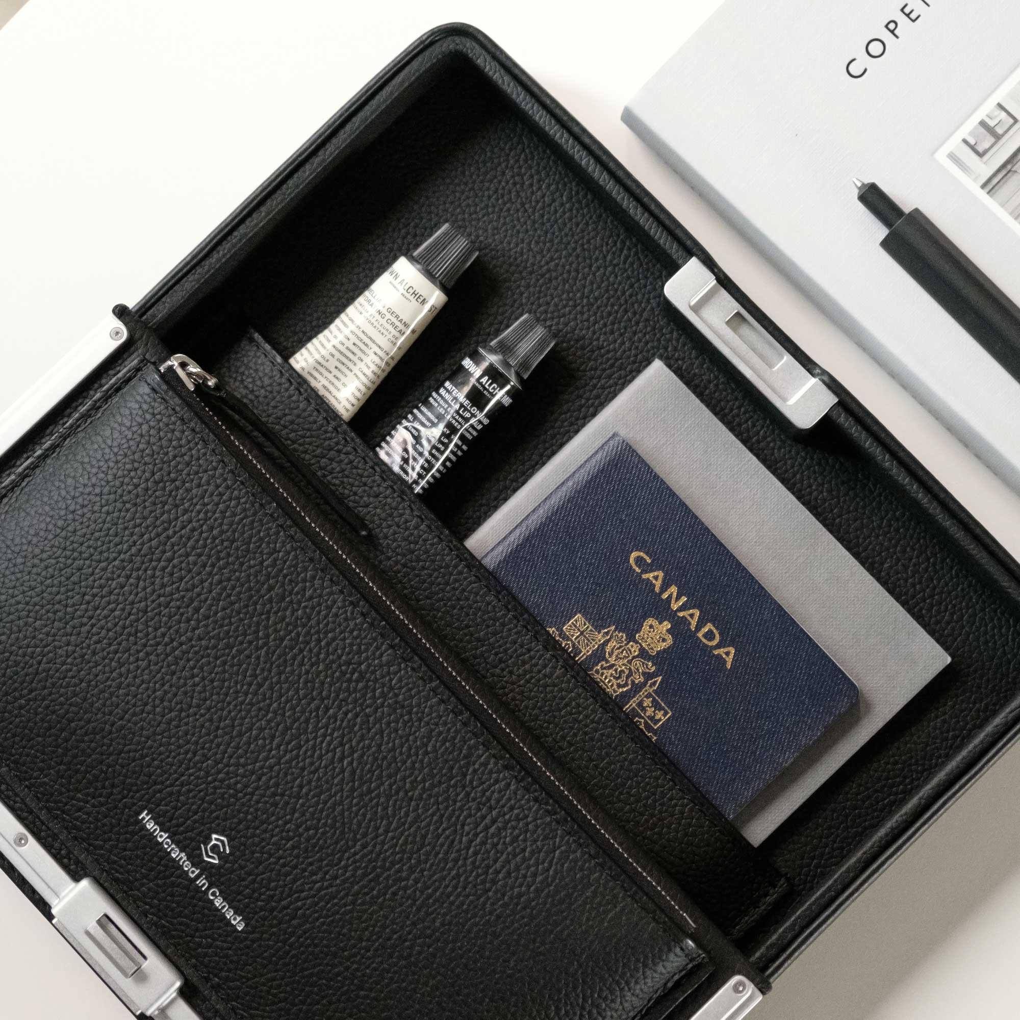 Lifestyle photo of open Fraser travel wallet holding all travel essentials including passport, phone, hand creams and more