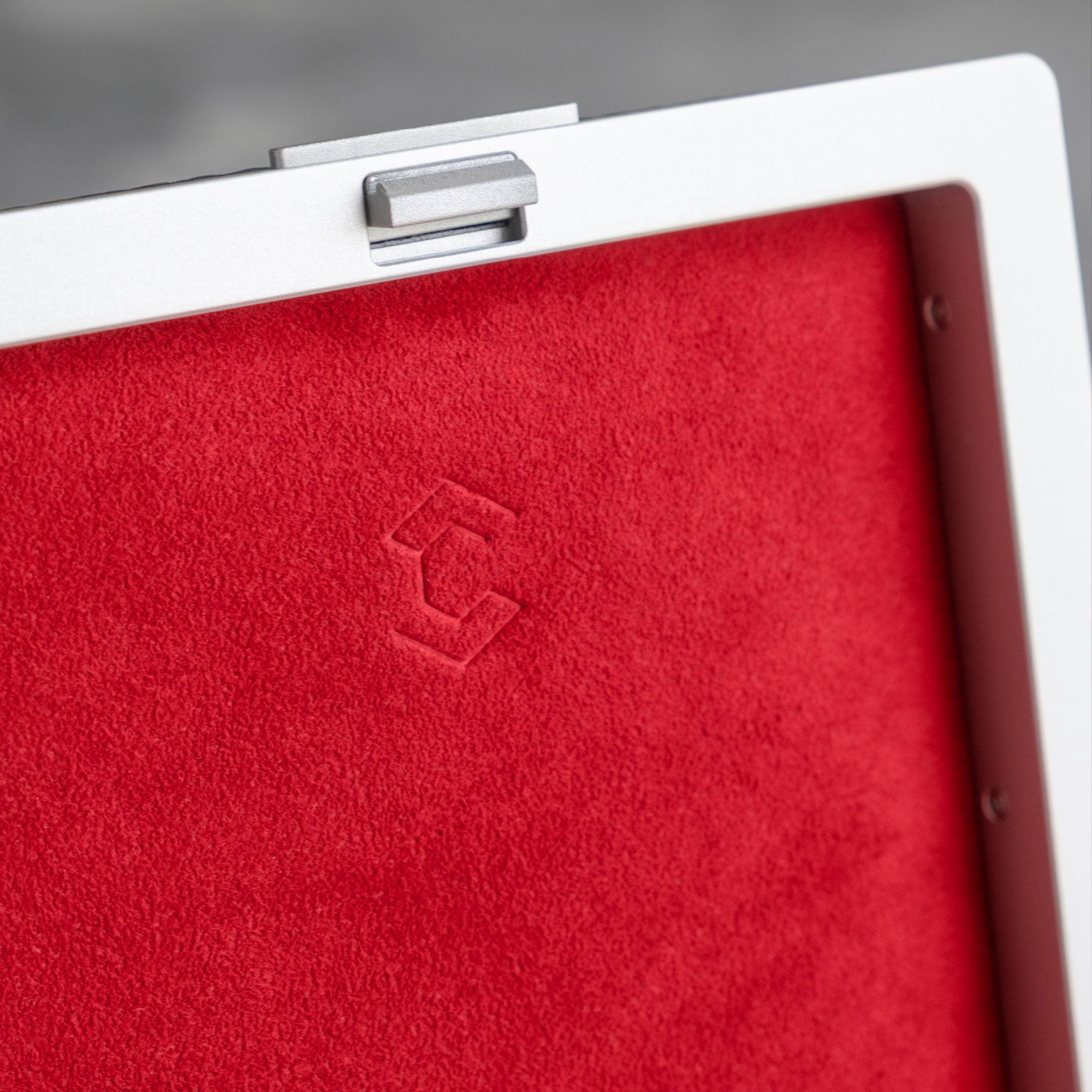 Closeup of debossed Charles Simon logo in crimson Alcantara on the Eaton 1 Special Edition Watch case