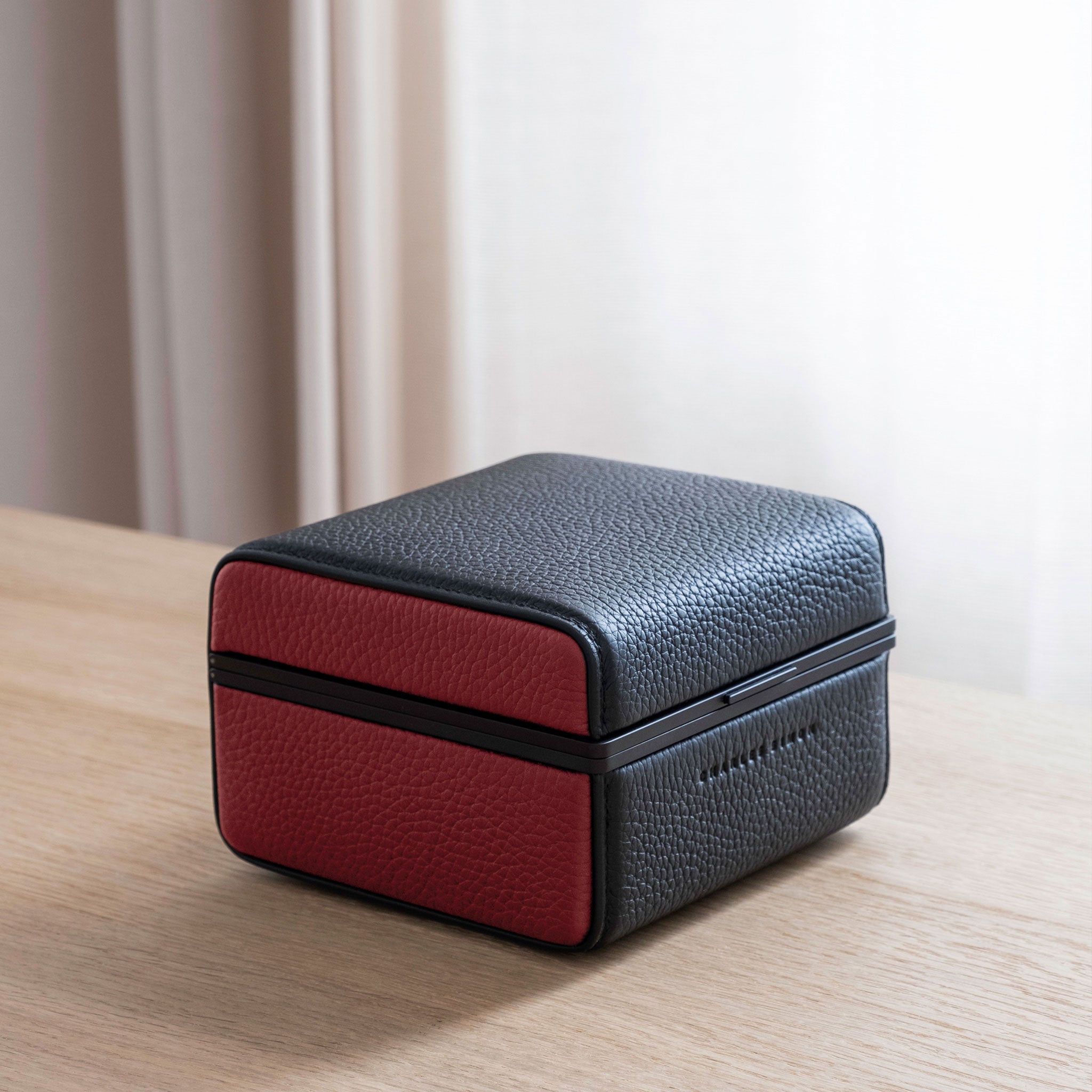 Lifestyle photo of closed Eaton 1 Watch case in black and contrasting red leather and black anodized aluminum