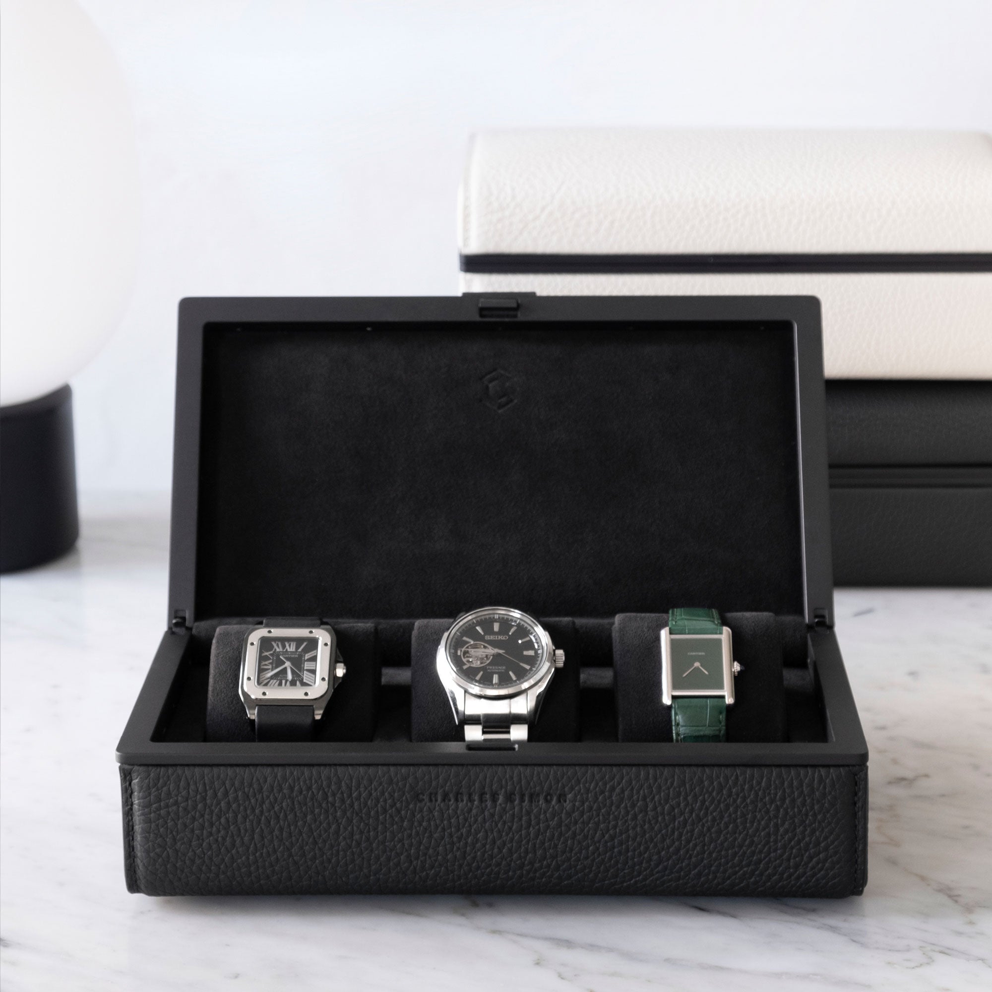 Lifestyle photo of minimalist Eaton 3 watch case handmade in Canada from black leather to hold 3 watches 