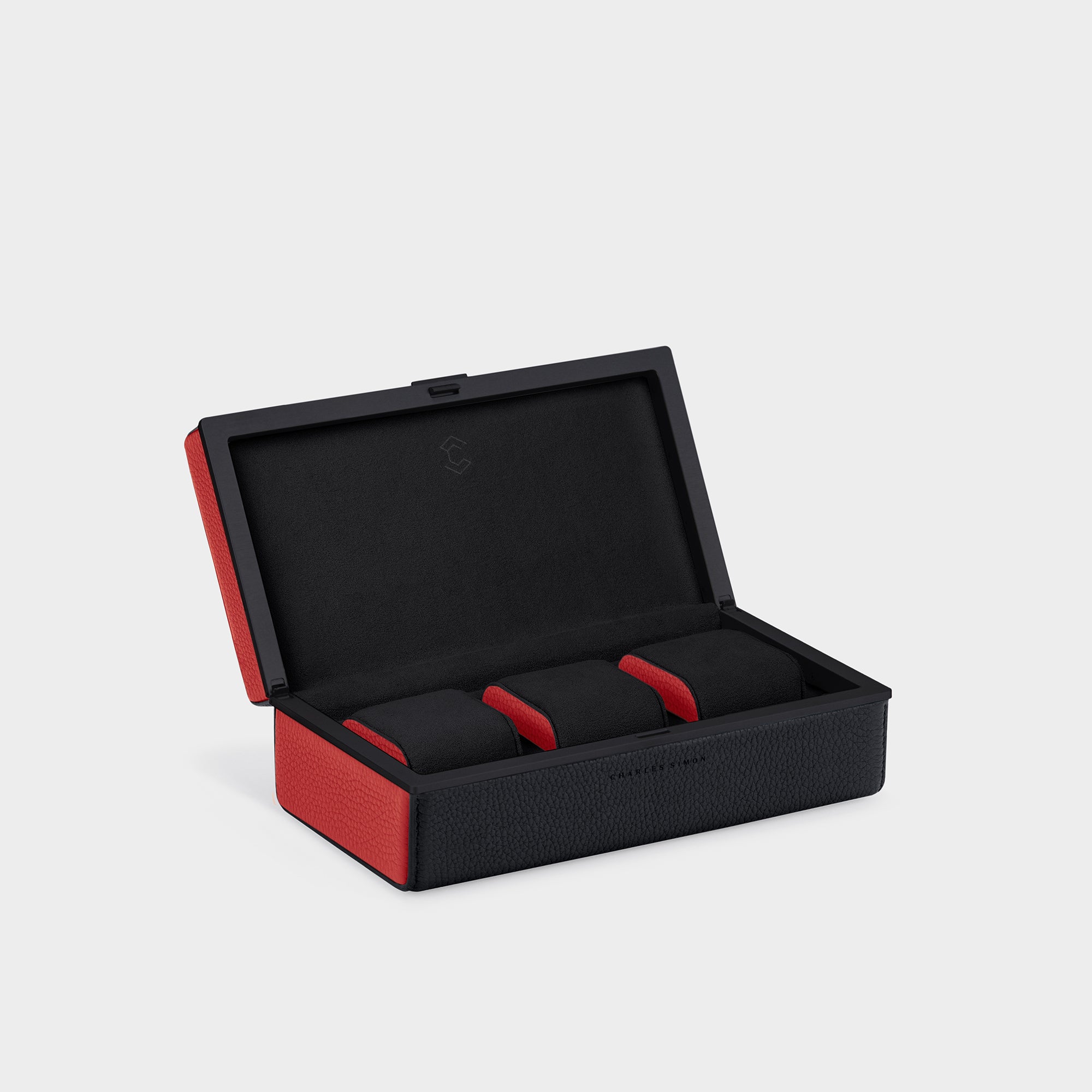 Bold handmade designer watch case for up to 3 watches.  Open Eaton 3 by Charles Simon featuring black leather with red leather accents, black anodized aluminum and black Alcantara with contrasting red leather accents on the cushion sides 