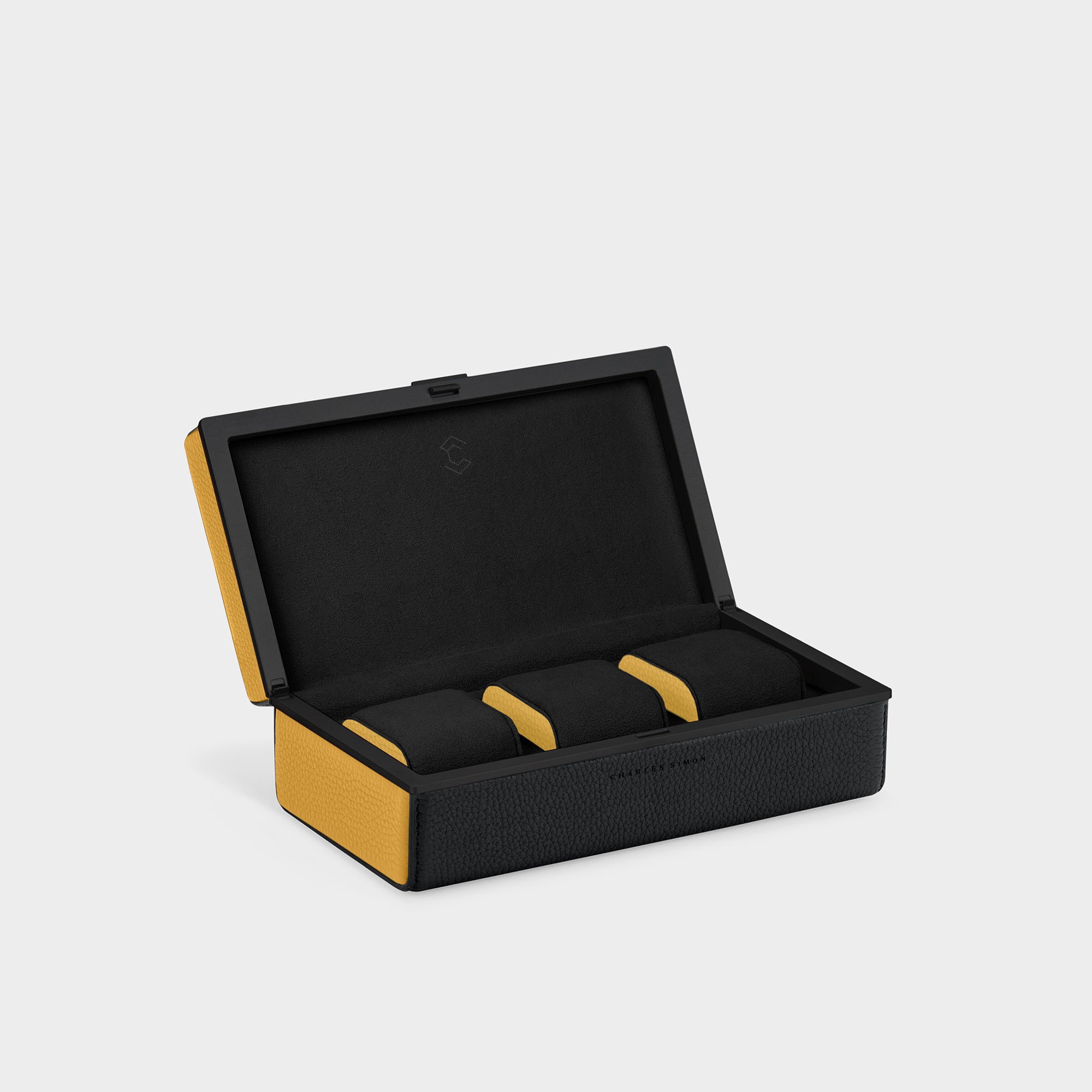 Bold handmade designer watch case for up to 3 watches. Open Eaton 3 by Charles Simon featuring black leather with yellow leather accents, black anodized aluminum and black Alcantara with contrasting yellow leather accents on the cushion sides
