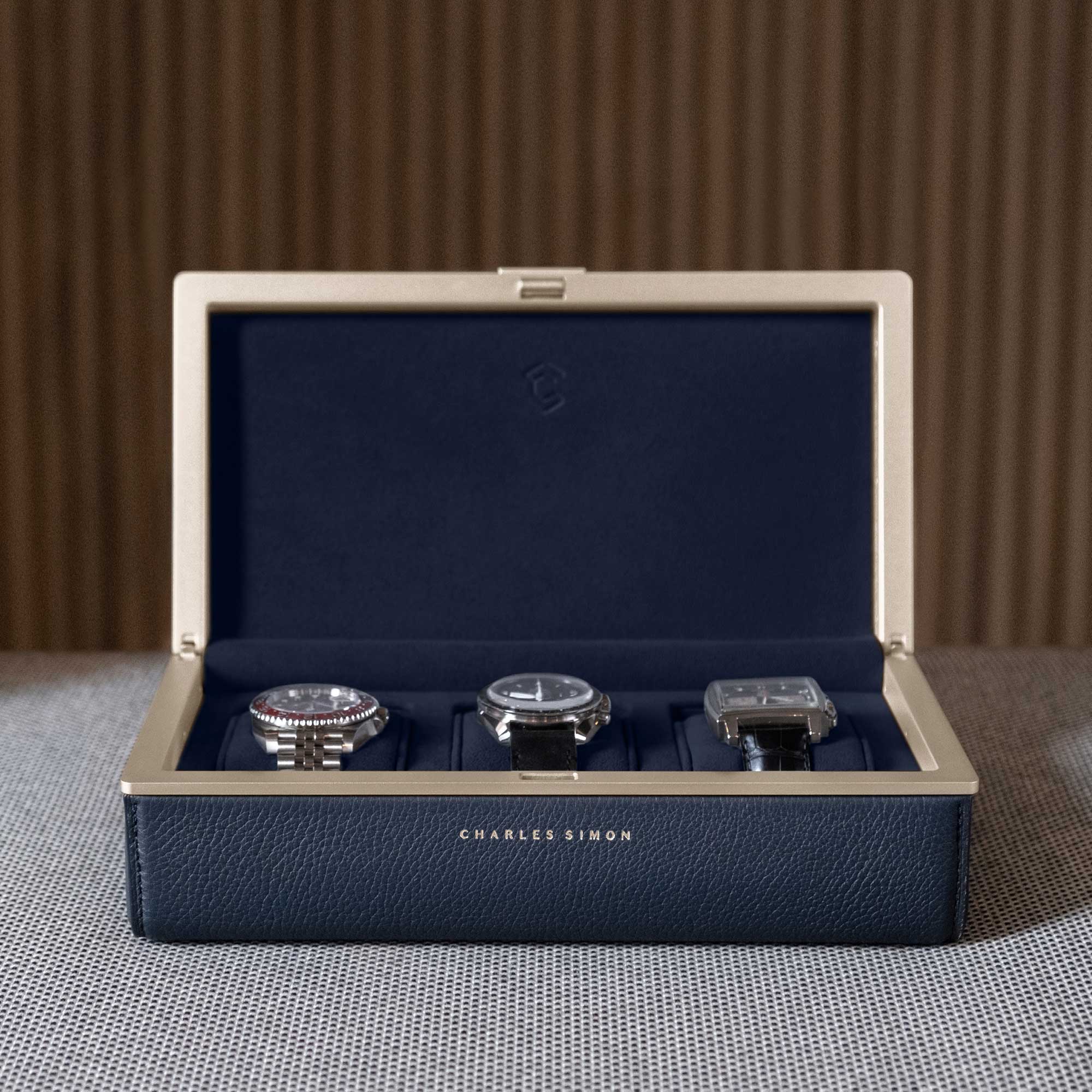 3 luxury watches elegantly displayed in the Eaton 3 Watch case in gold casing, marine leather and deep blue interior.