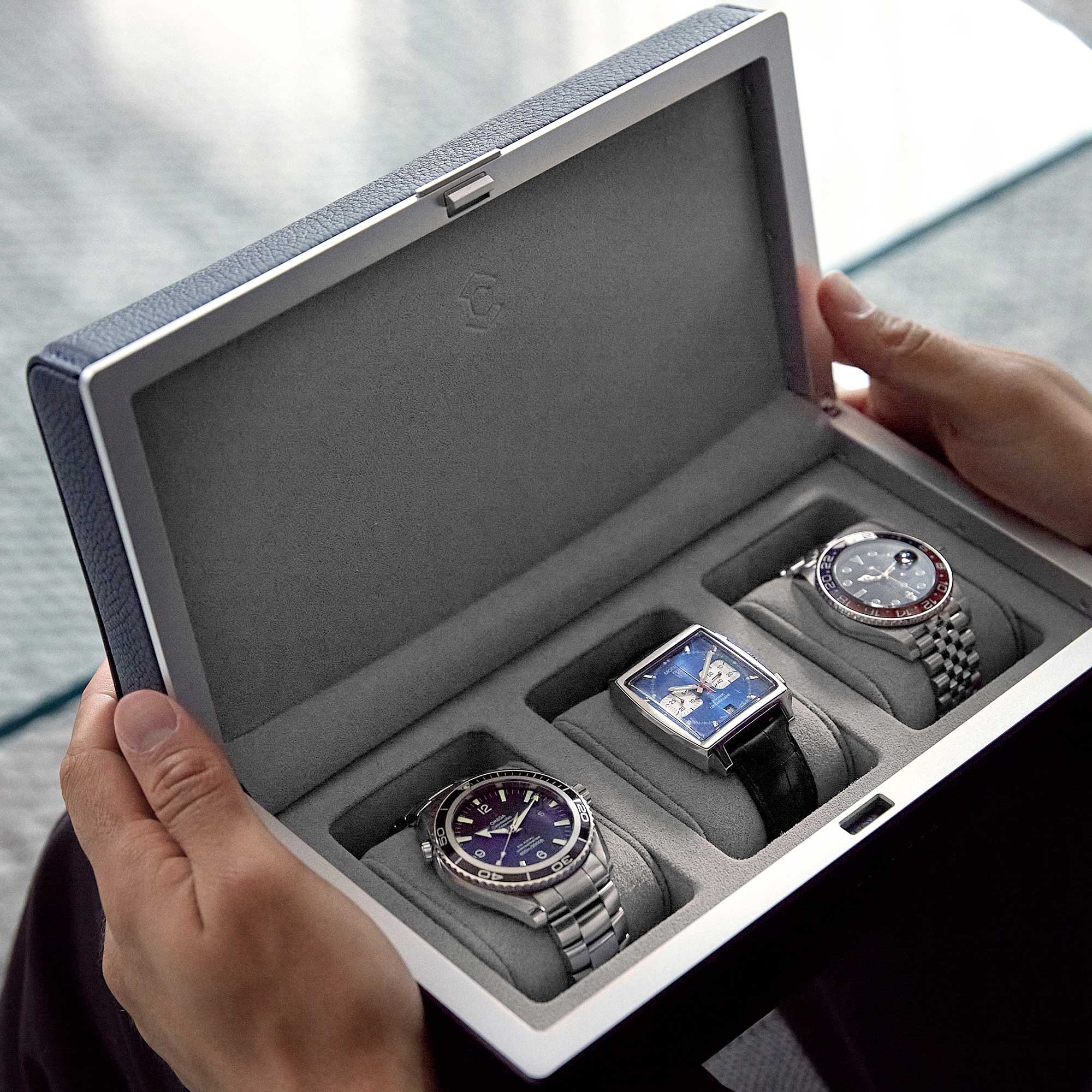 Lifestyle shot of open Eaton 3 watch case containing three luxury men’s watches