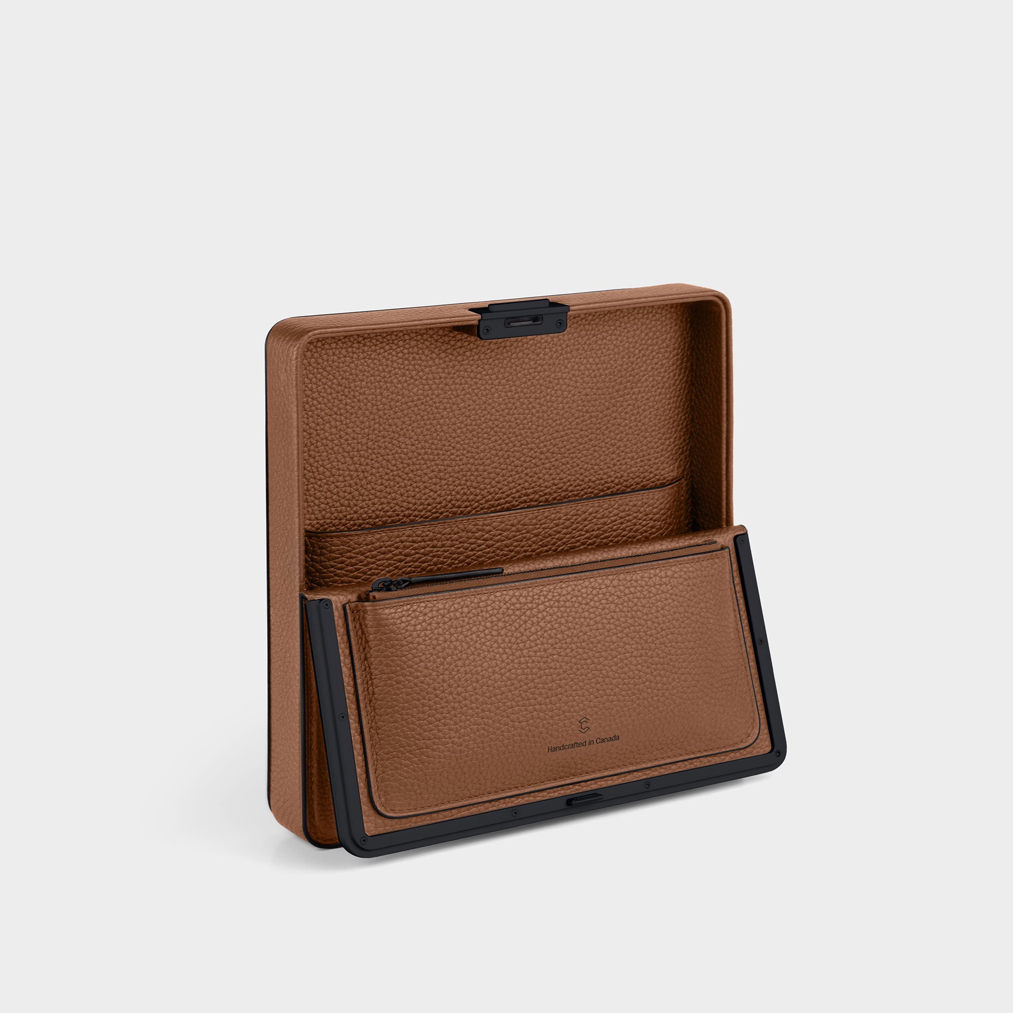 Product shot of open Fraser travel wallet in tan with black contrasting edges showing the convenient zipped pouch and large central compartment 