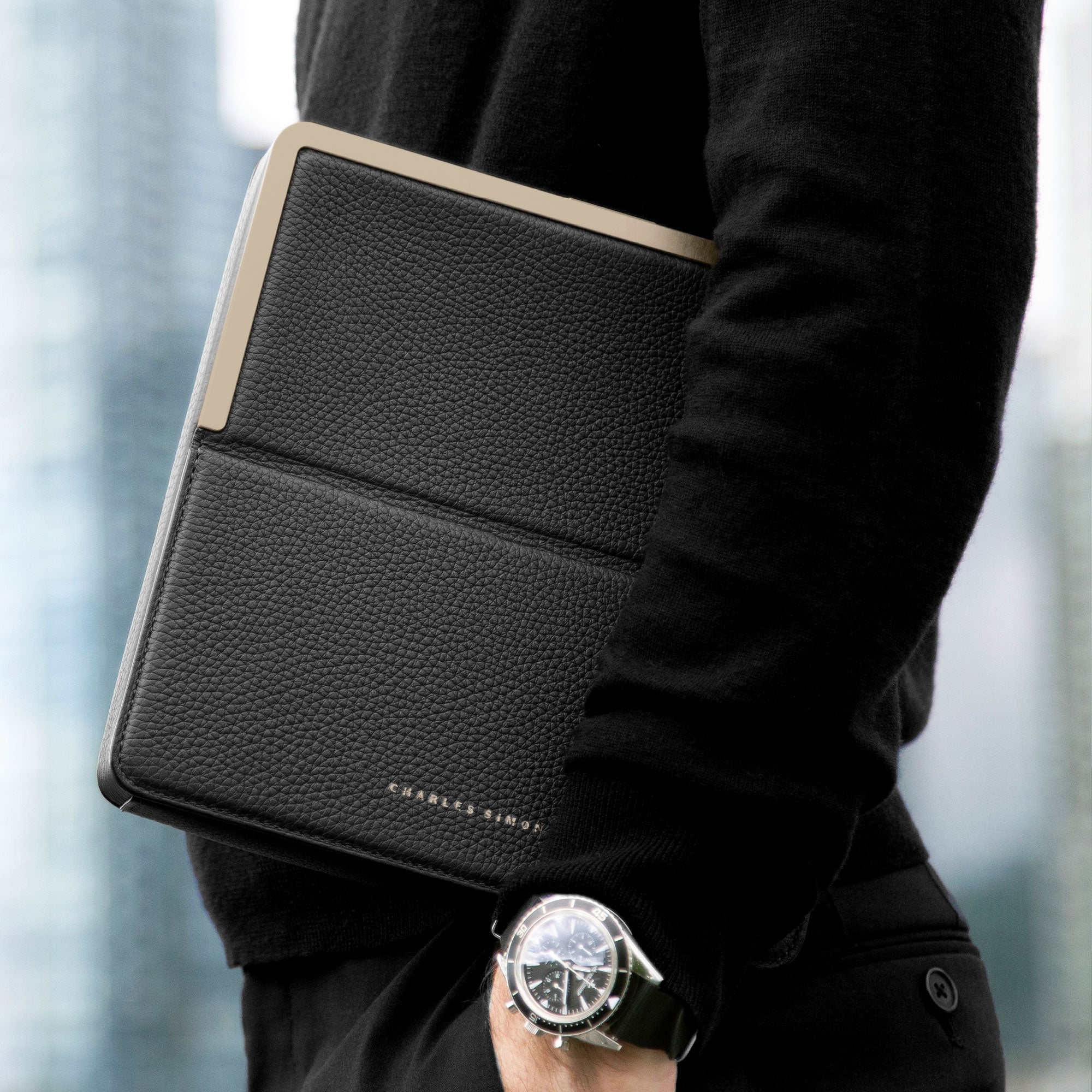 Lifestyle photo of stylish business man holding his luxury travel wallet in black leather and gold
