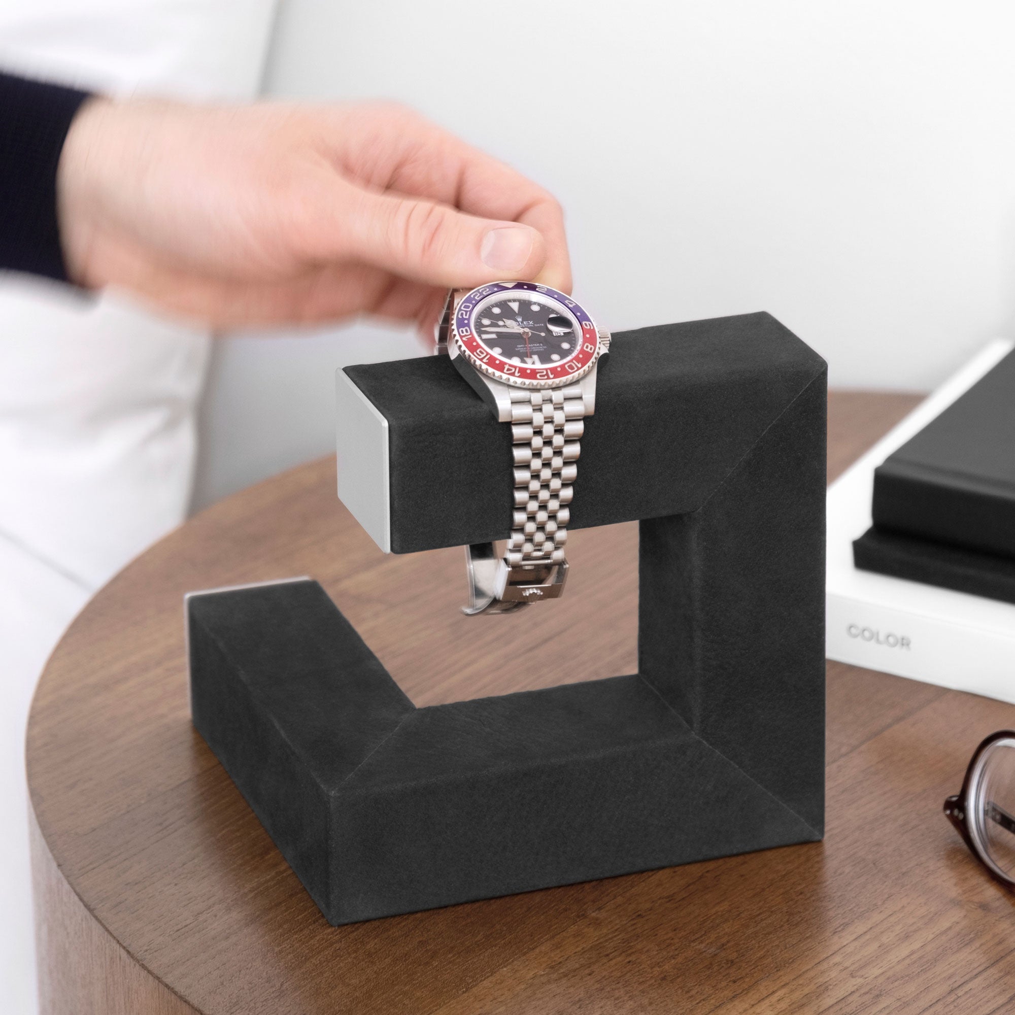 Lifestyle shot of Hudson 1 in grey holding luxury men's watch