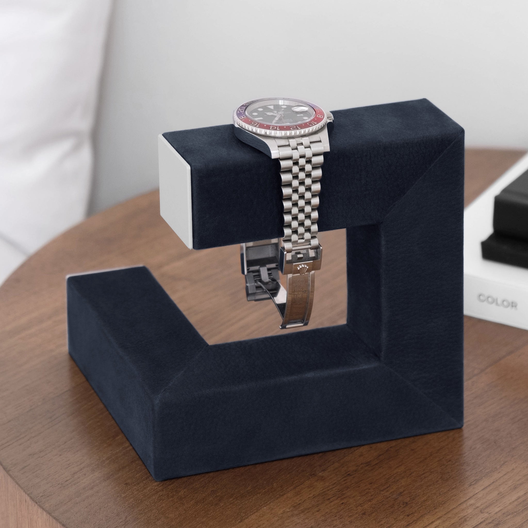 Lifestyle shot of luxury watch stand holding 1 Rolex GMT Pepsi watch in modern bedroom setting