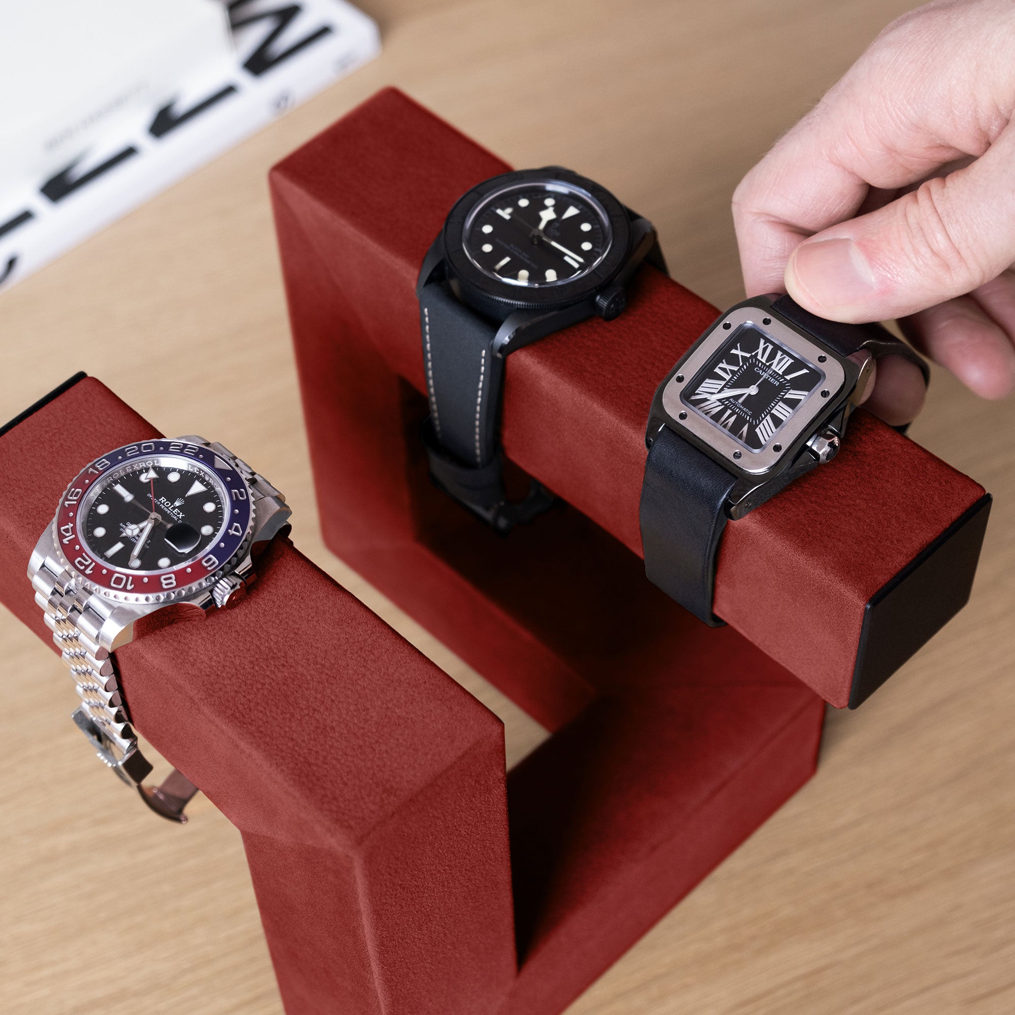 Lifestyle shot of 3 watches placed on crimson Hudson 3 designer watch stand