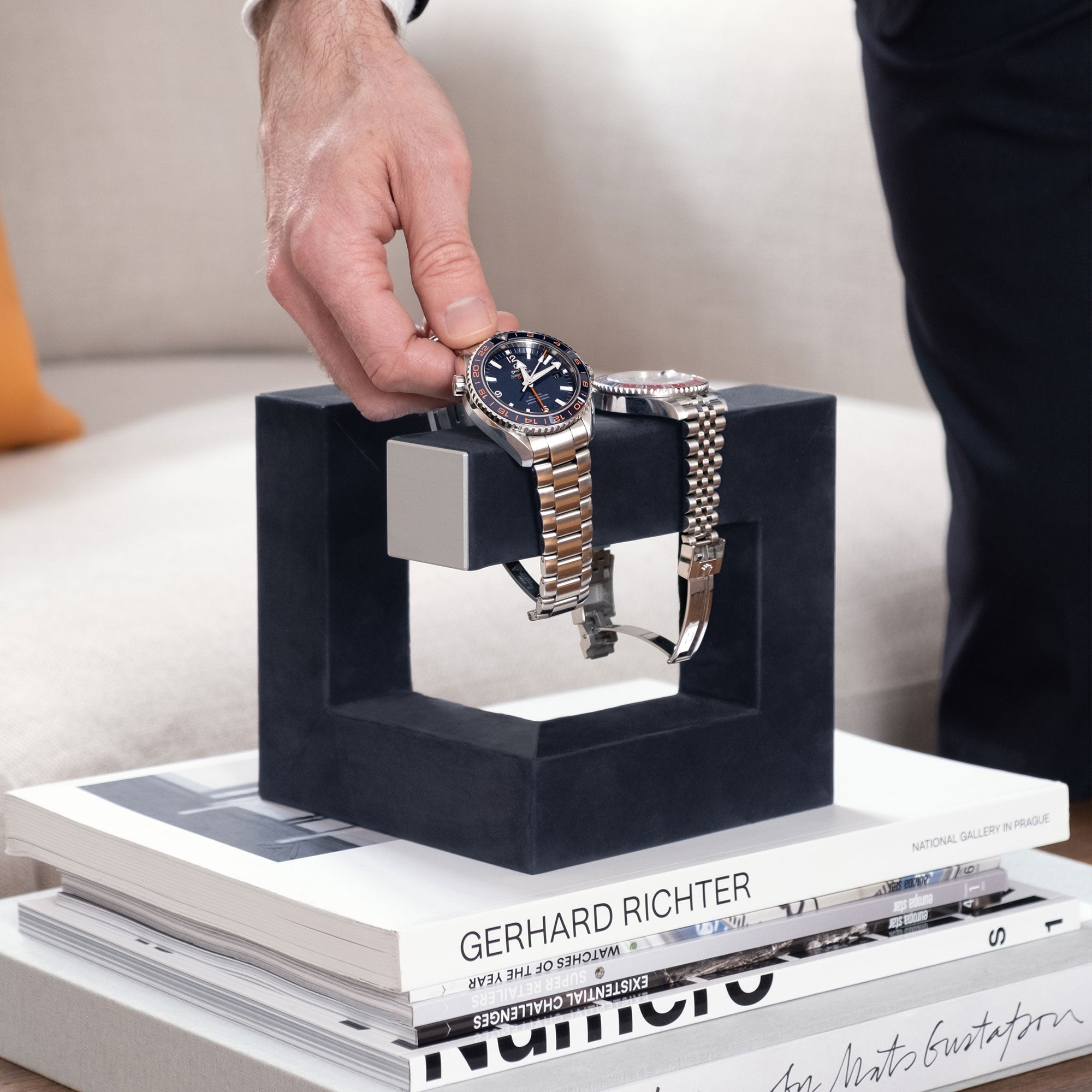 Lifestyle photo of man taking his watch from his dusty blue Hudson 3 Watch stand