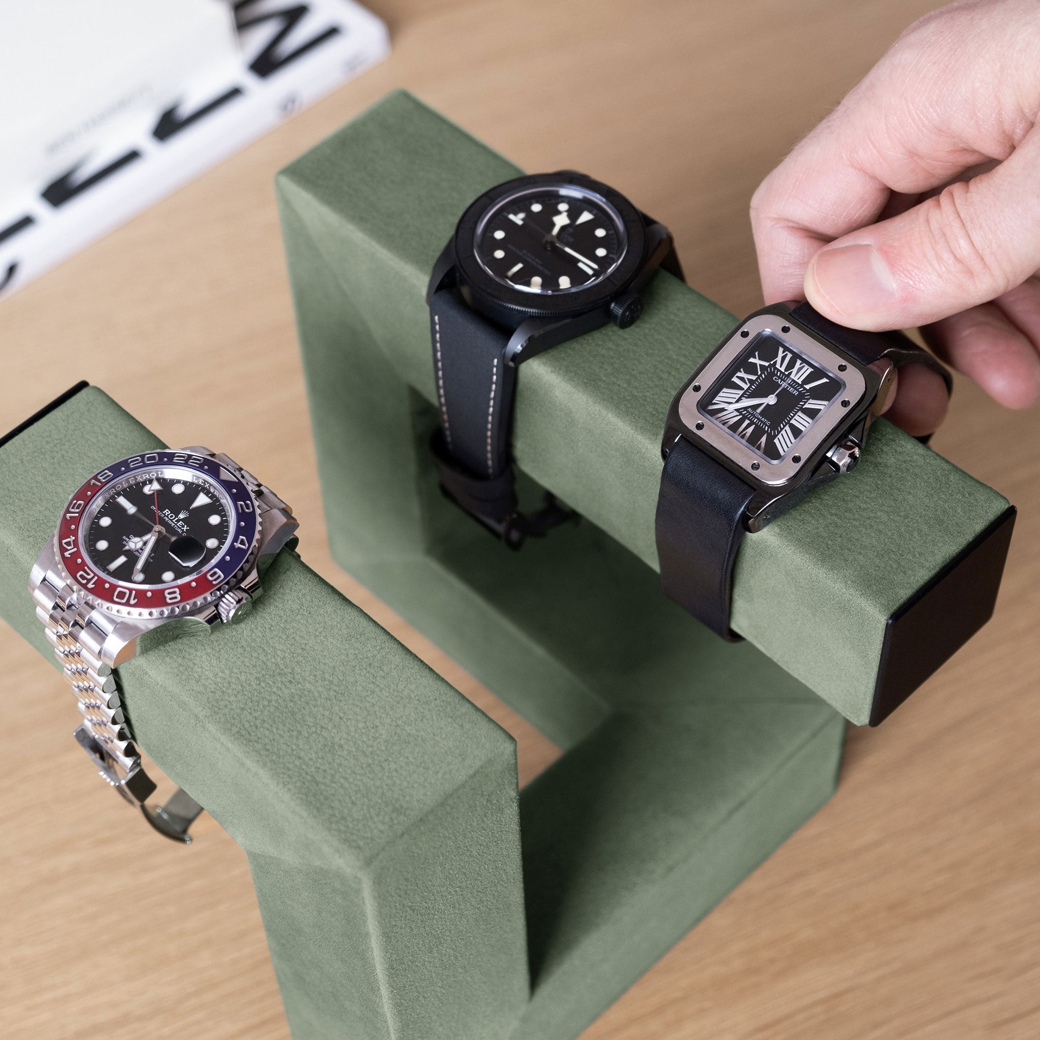 Lifestyle photo of minimalist watch stand holding 3 luxury watches
