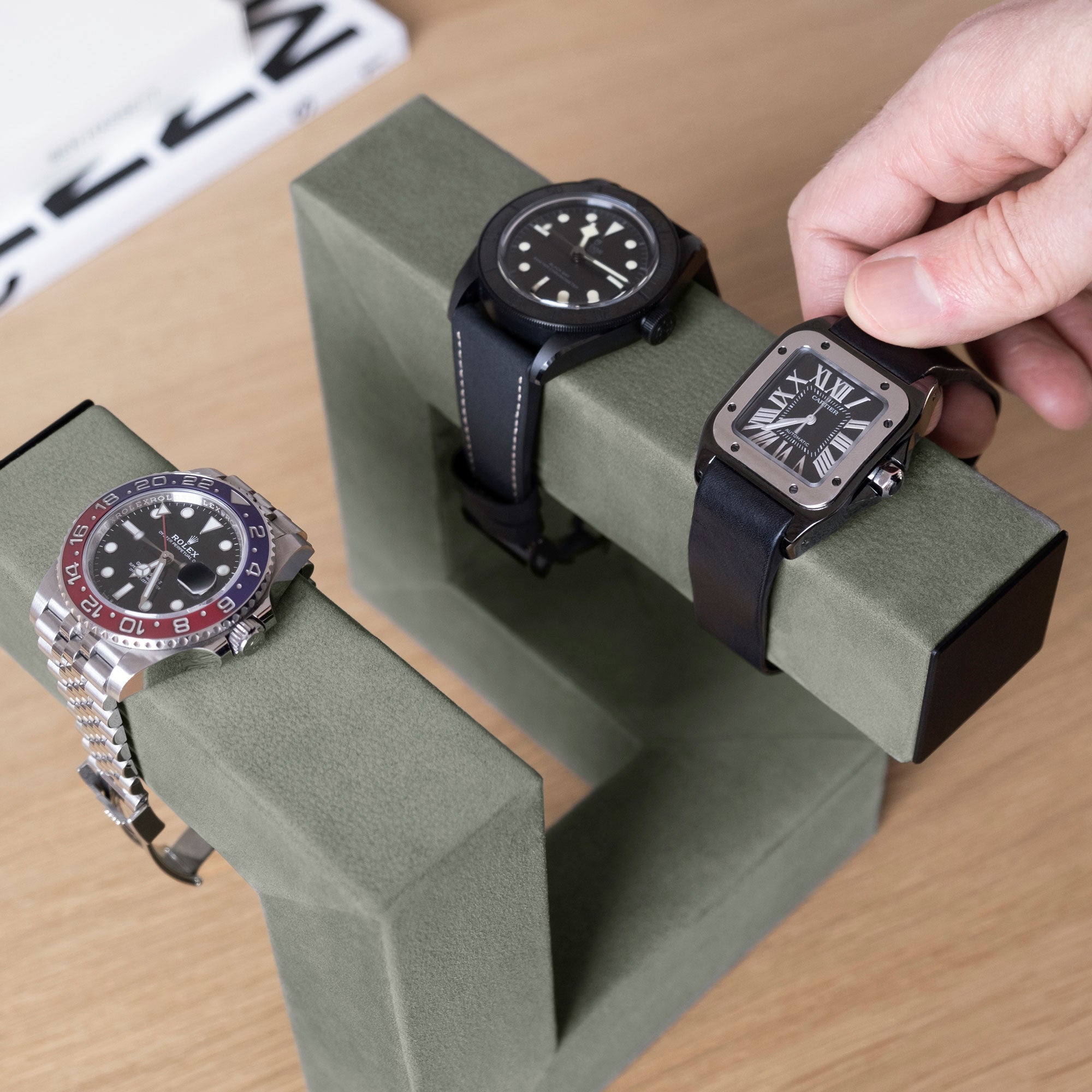 Lifestyle photo of minimalist watch stand holding 3 luxury watches