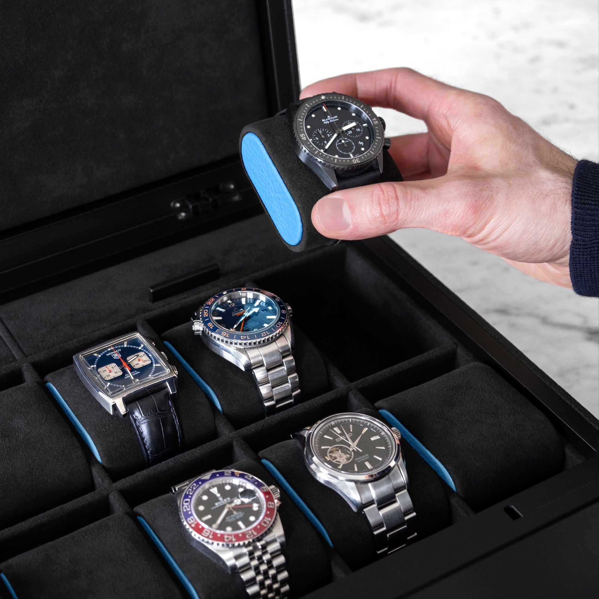 Closeup shot of Blancpain luxury watch on removable Alcantara cushion with sky blue accent in an all black Mackenzie 12 watch briefcase