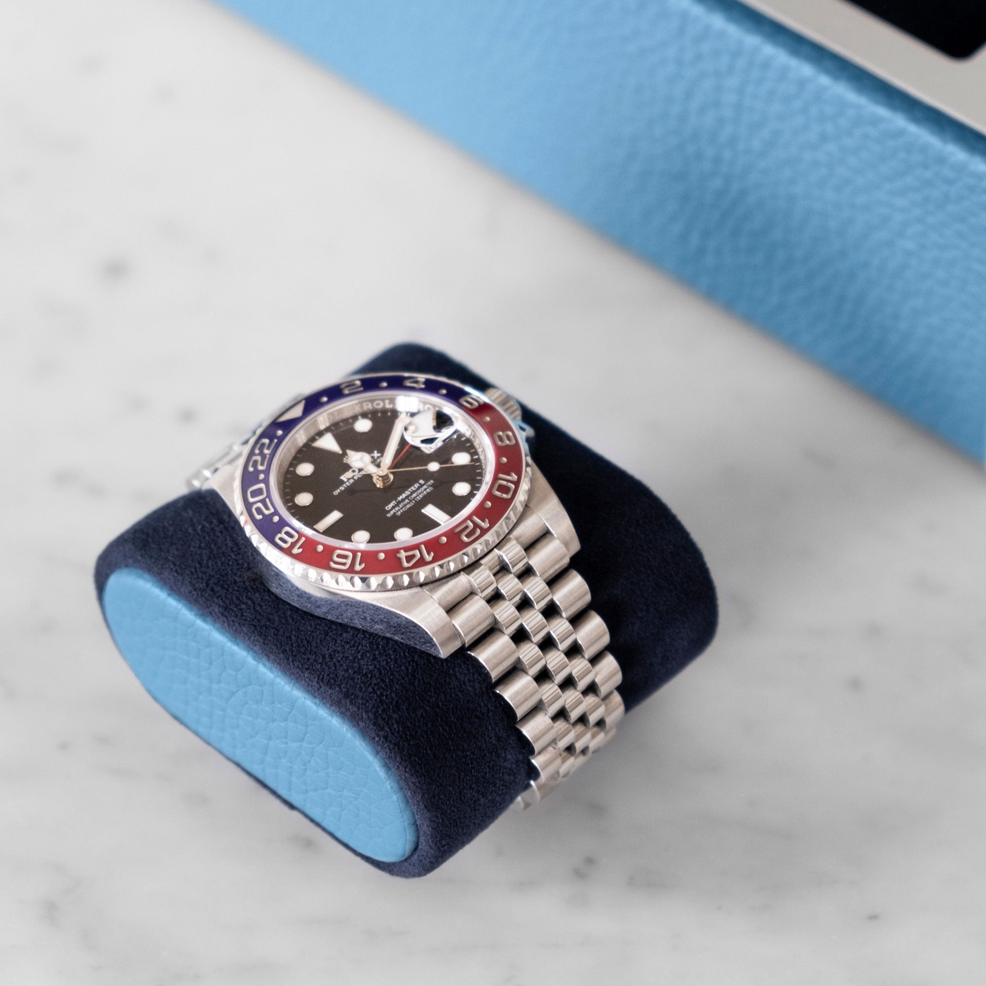 Removable Alcantara watch cushion with sky blue leather side accents with Rolex watch