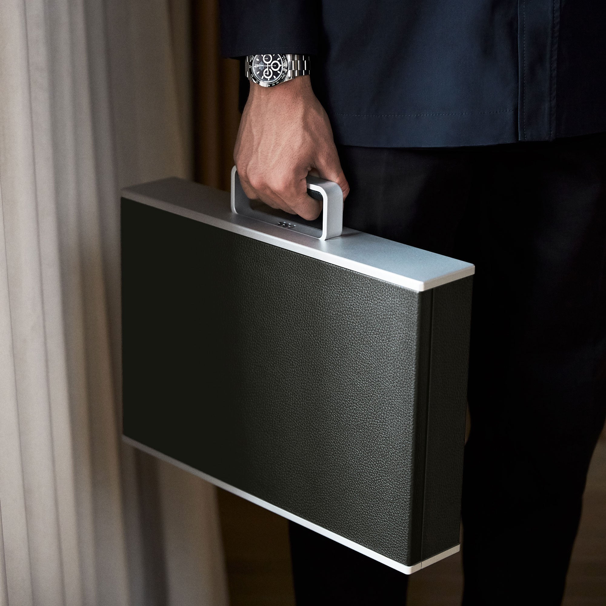 Stylish man holding his grey and graphite leather Mackenzie Briefcase