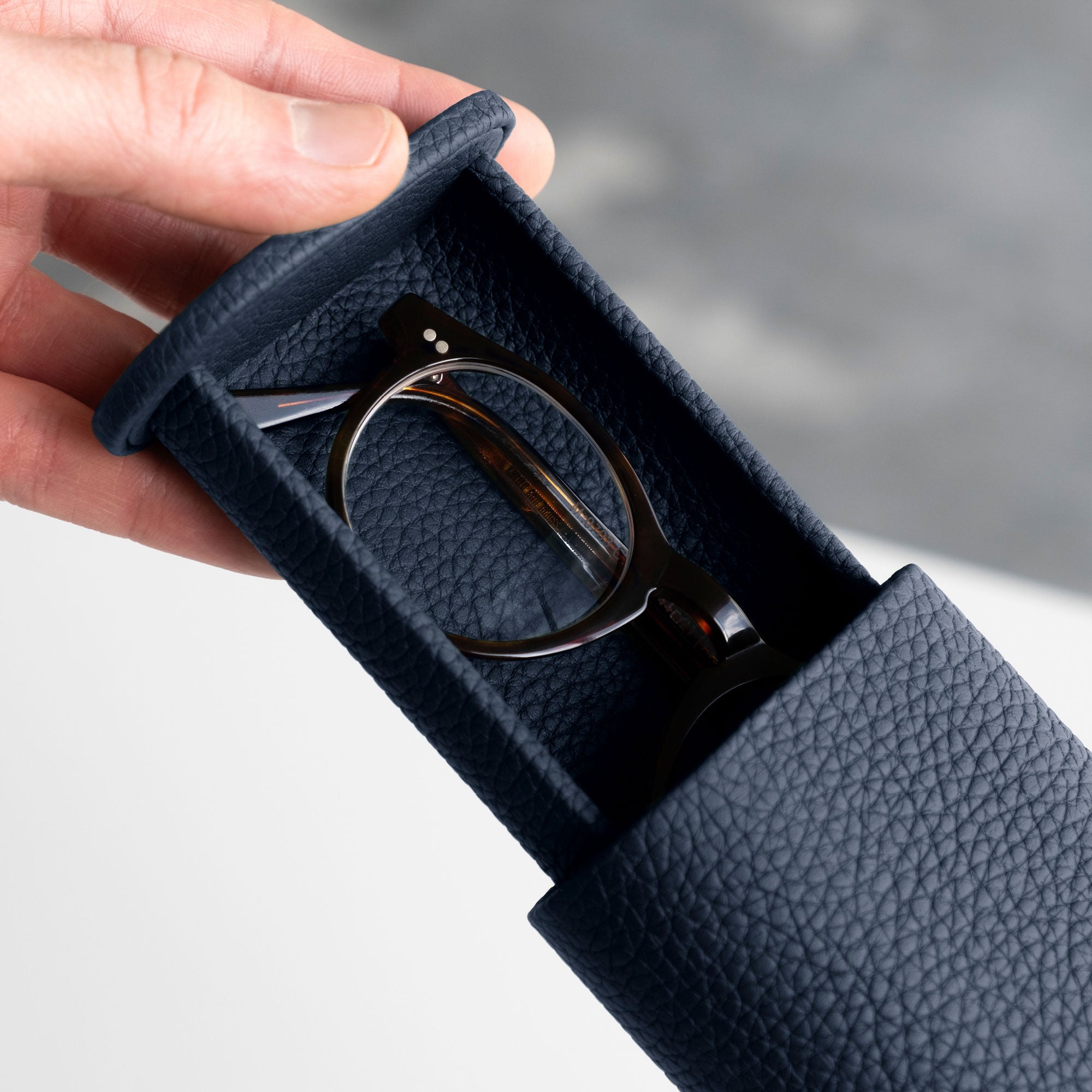 Man opening his marine Oscar Tall Watch roll containing a pair of glasses