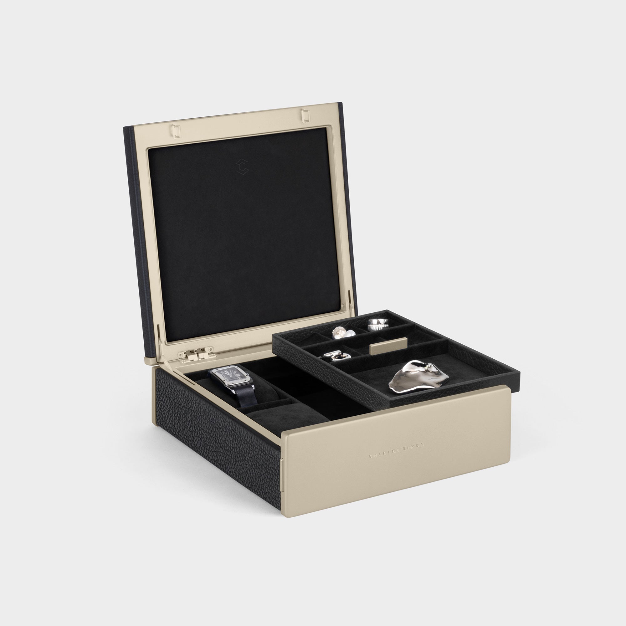 Open Taylor 2 Watch and Jewelry box with gold framing and black leather exterior. The handmade Taylor 2 Watch and Jewelry box features convenient compartments to organize and store your jewelry and watch collection in style. 