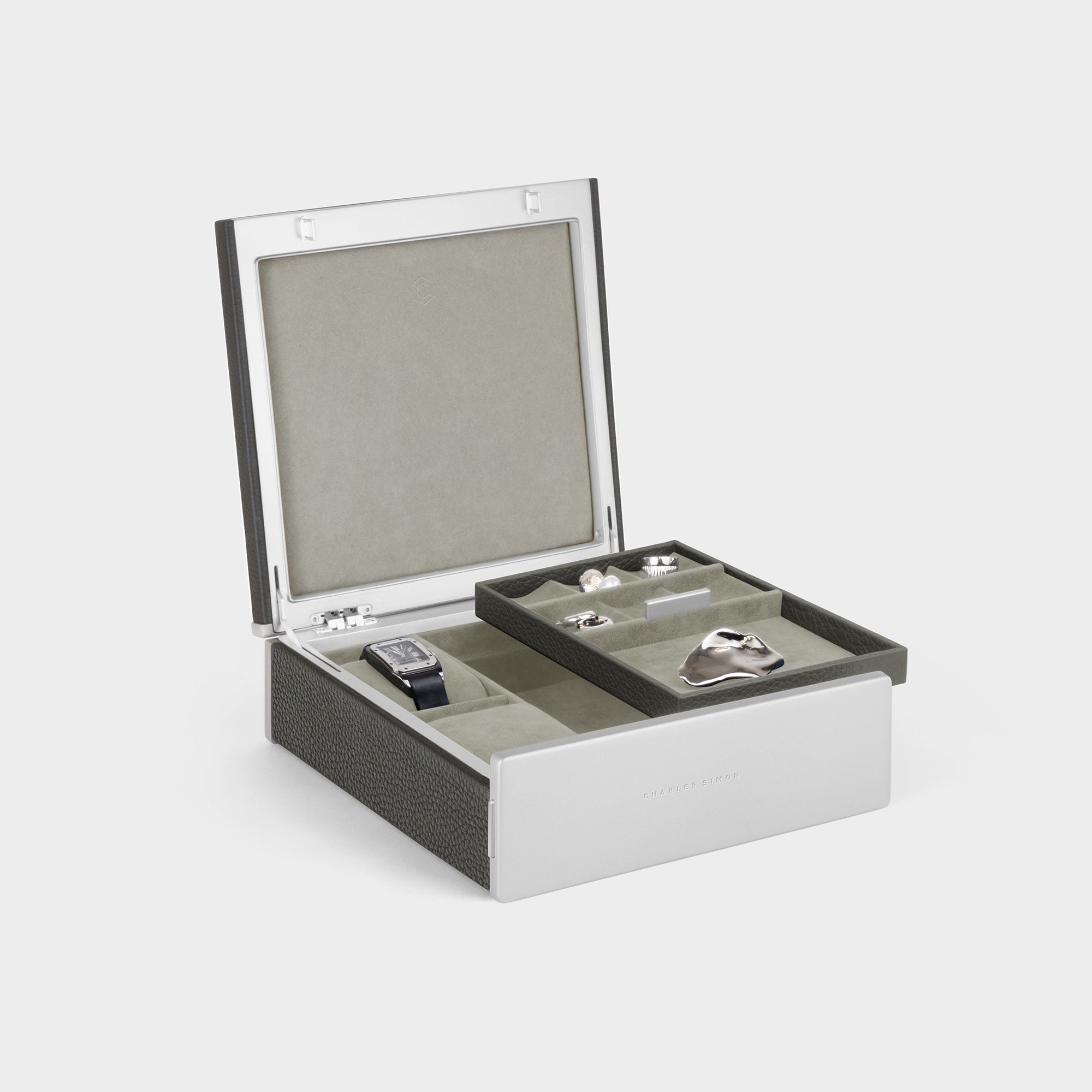 Product photo of open Taylor 2 Watch and Jewelry box  in graphite leather and seasand interior. The removable jewelry tray is placed on the carbon fiber and anodized aluminum frame of the Spence 6 Watch box. 