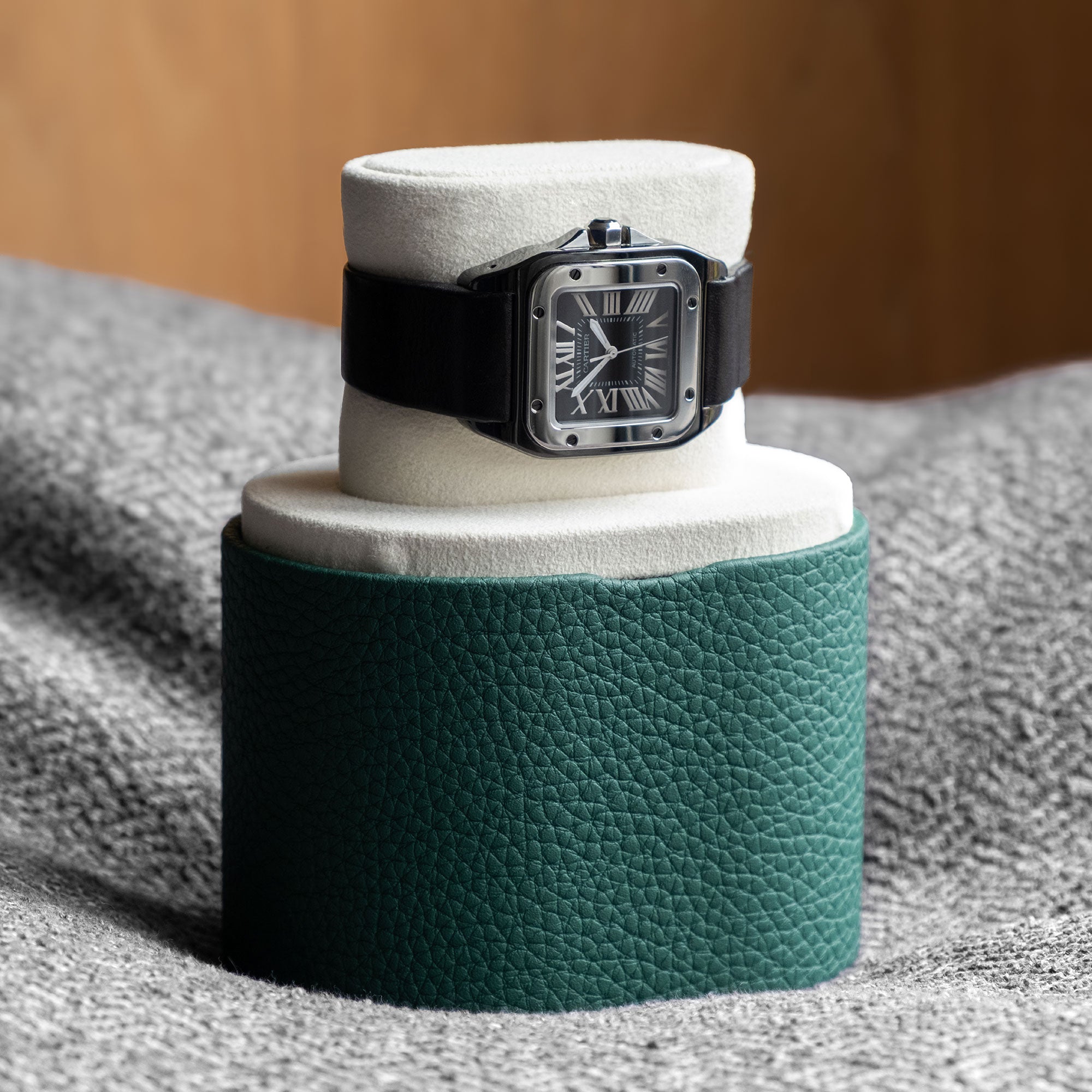 Men’s watch displayed on Theo Leather Watch roll in watch stand position. Handmade in Canada from emerald young bull leather and gold anodized aluminum.