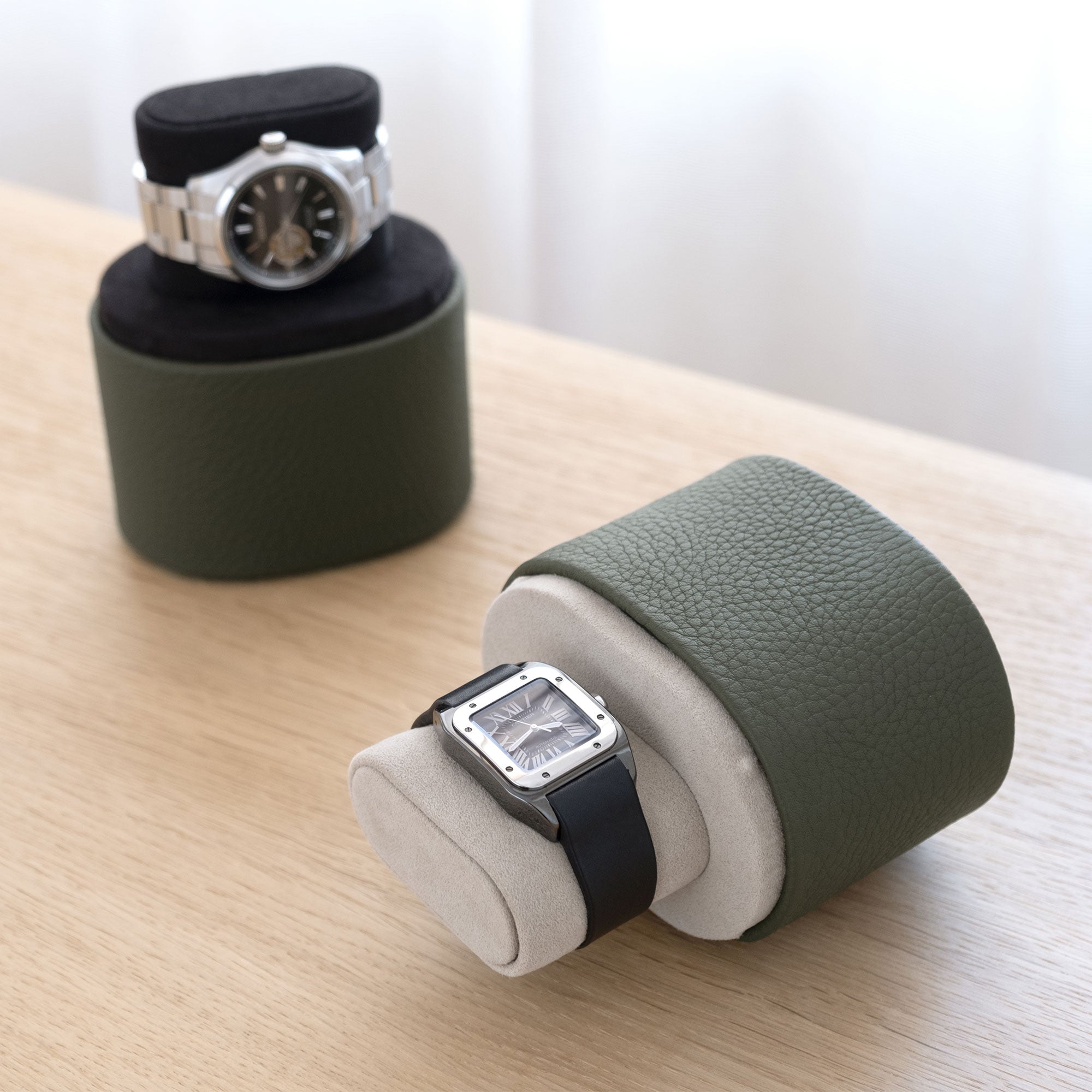 Lifestyle photo of open Theo handmade leather watch rolls in khaki holding luxury watches