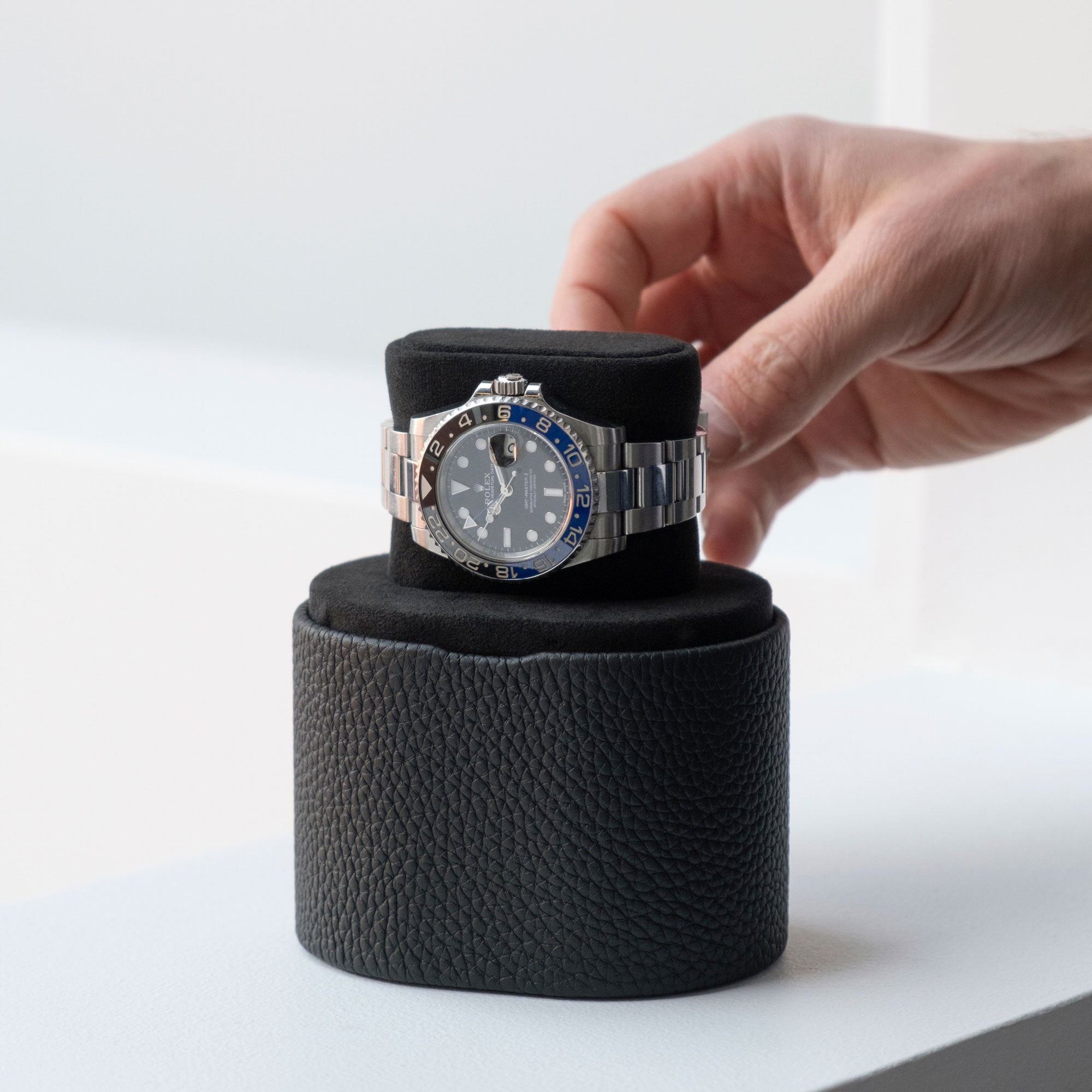 Man taking Batman Rolex from the Theo Watch roll in black leather and Notte Alcantara cushion