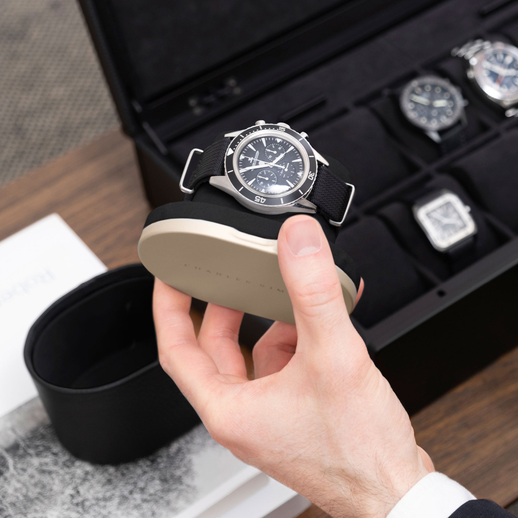 Lifestyle photo of open gold watch roll by Charles Simon holding luxury watch while traveling