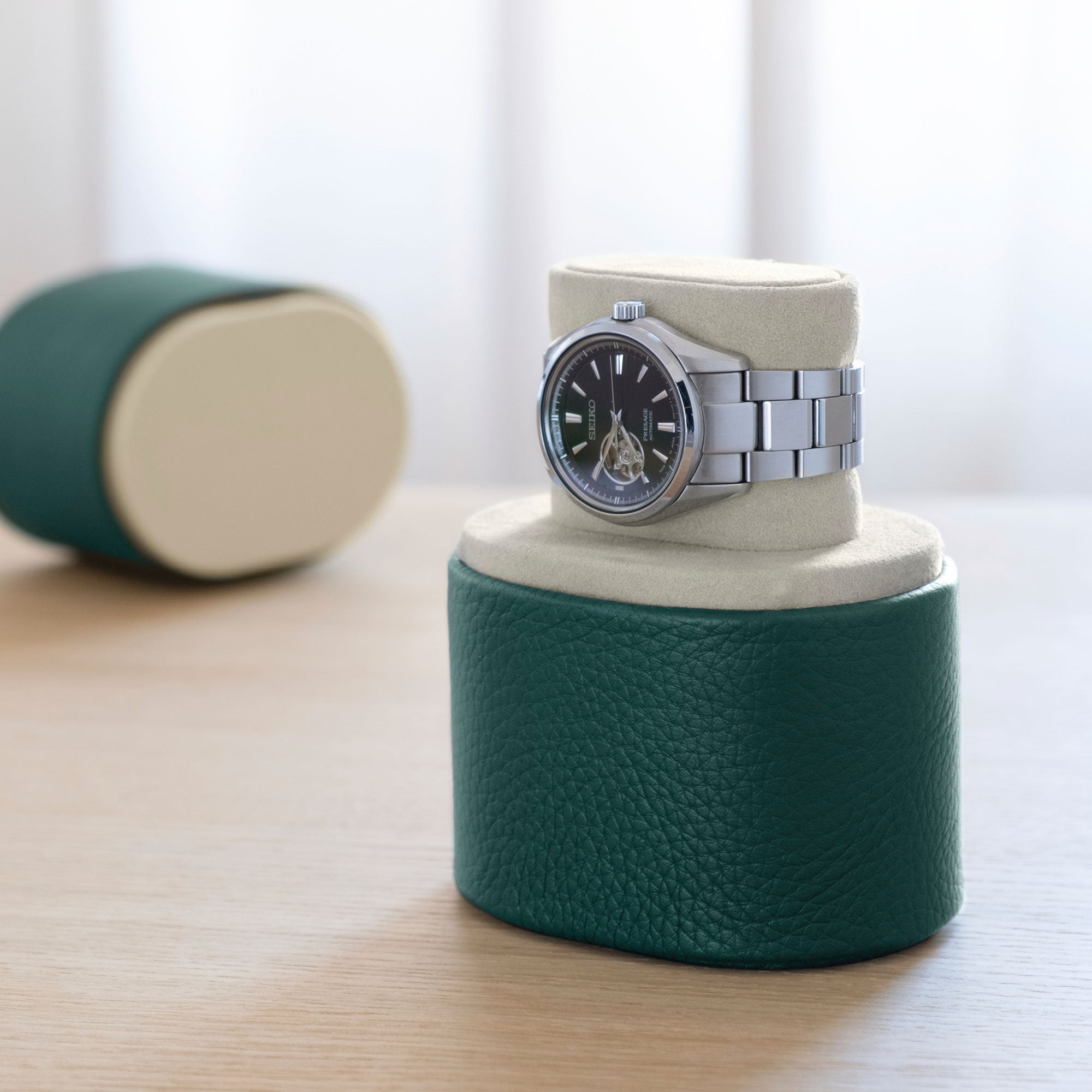 Men's watch displayed on Theo Watch roll in watch stand position. Handmade in Canada from emerald young bull leather and gold anodized aluminum.