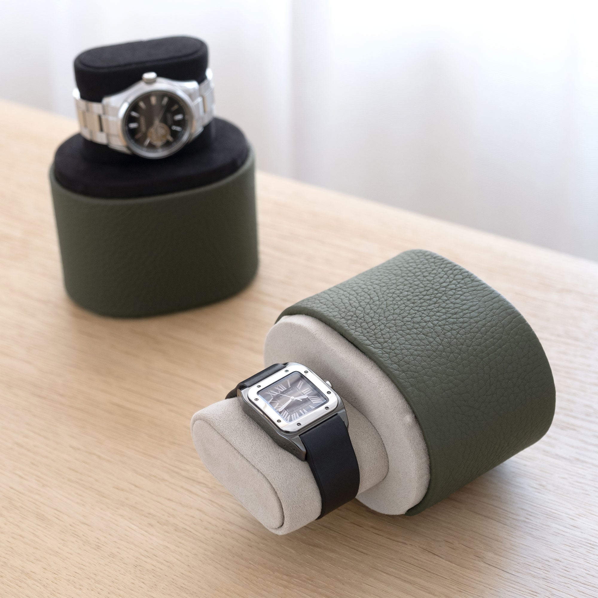 Lifestyle photo of open Theo handmade watch rolls in khaki leather holding luxury watches
