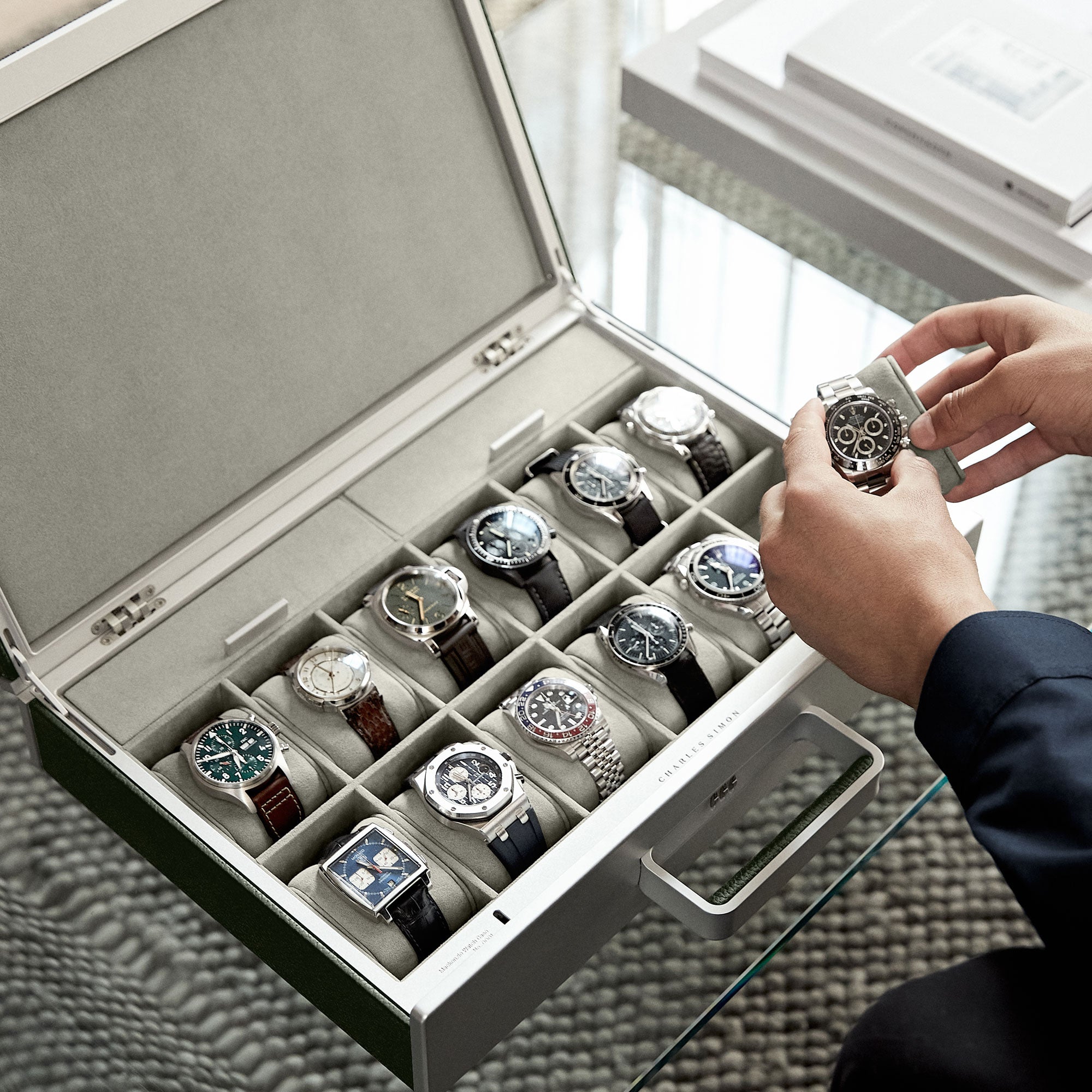 Lifestyle shot of open Mackenzie watch case containing watch collection of 12 luxury men’s watches