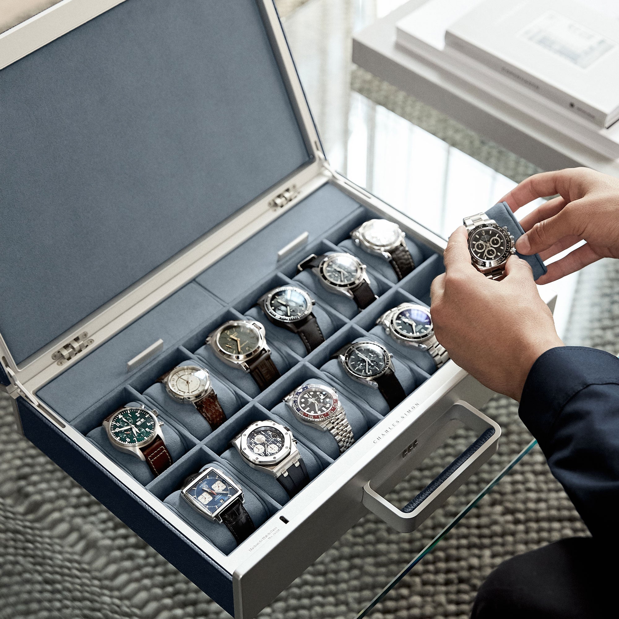 Lifestyle shot of marine leather Mackenzie watch briefcase filled with luxury men's watches including Rolex, Panerai, Patek