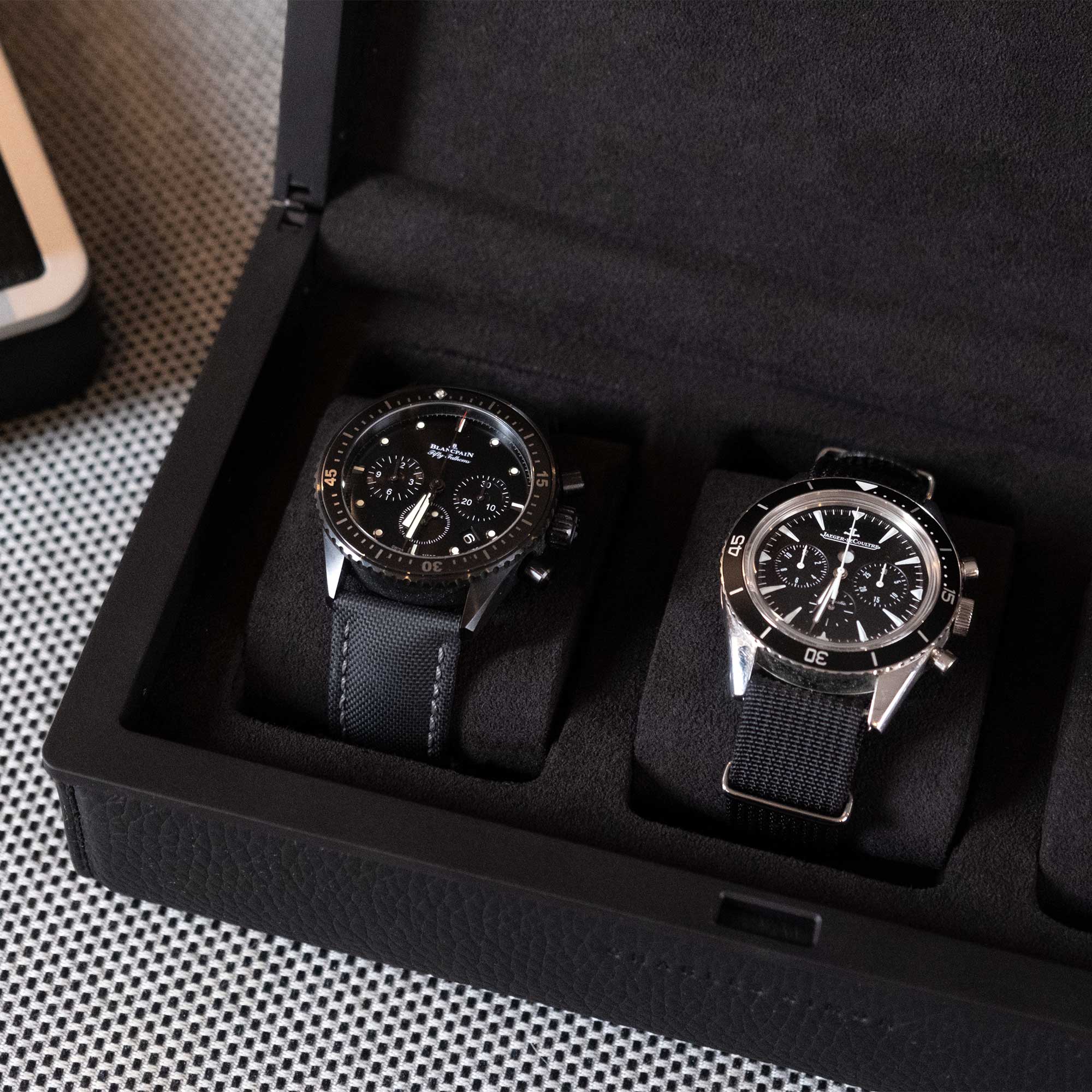Lifestyle closeup shot of all black Eaton 3 watch case by Charles Simon holding luxury men's watches