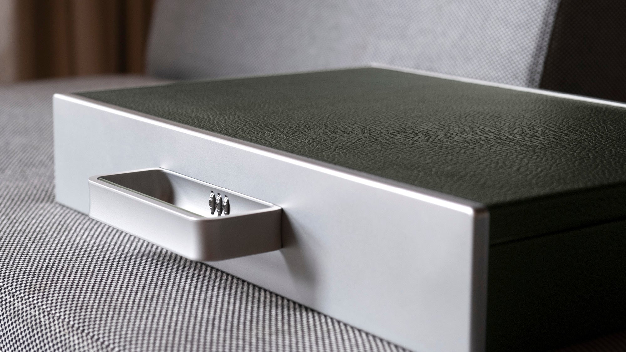 Detail shot of handle and protective lock of the Mackenzie Briefcase in grey and khaki leather