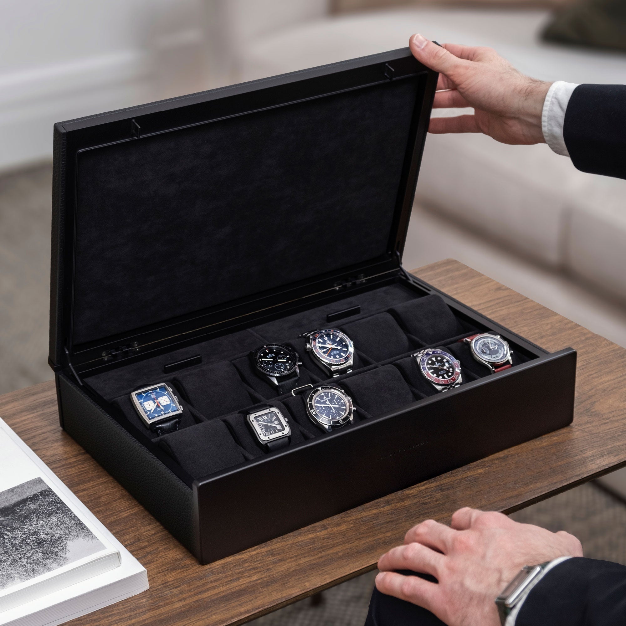 Lifestyle photo of man opening all black Spence 12 Watch box with luxury watch collection displayed inside