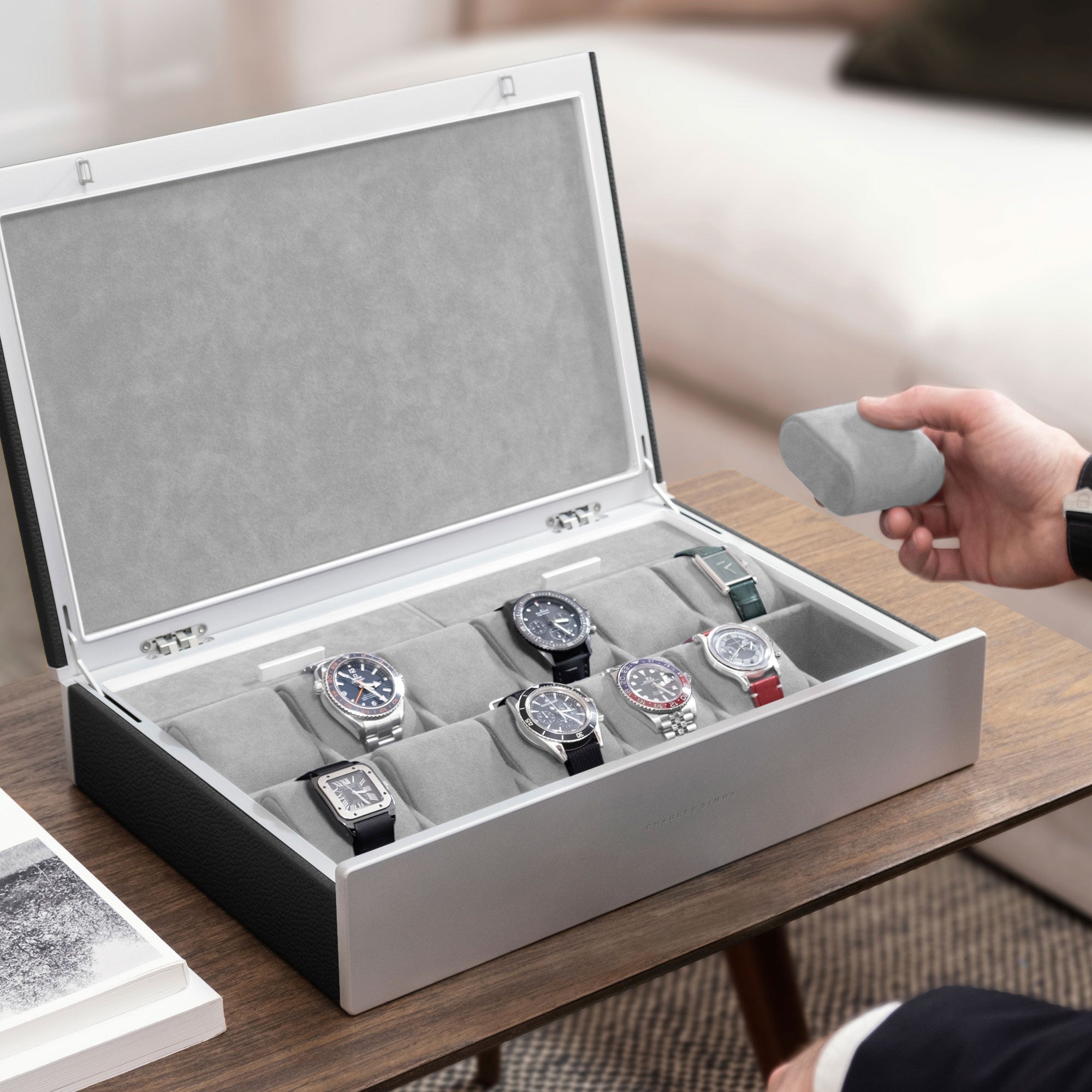 Lifestyle photo of man opening black leather and fog grey interior Spence 12 Watch box with luxury watch collection displayed inside