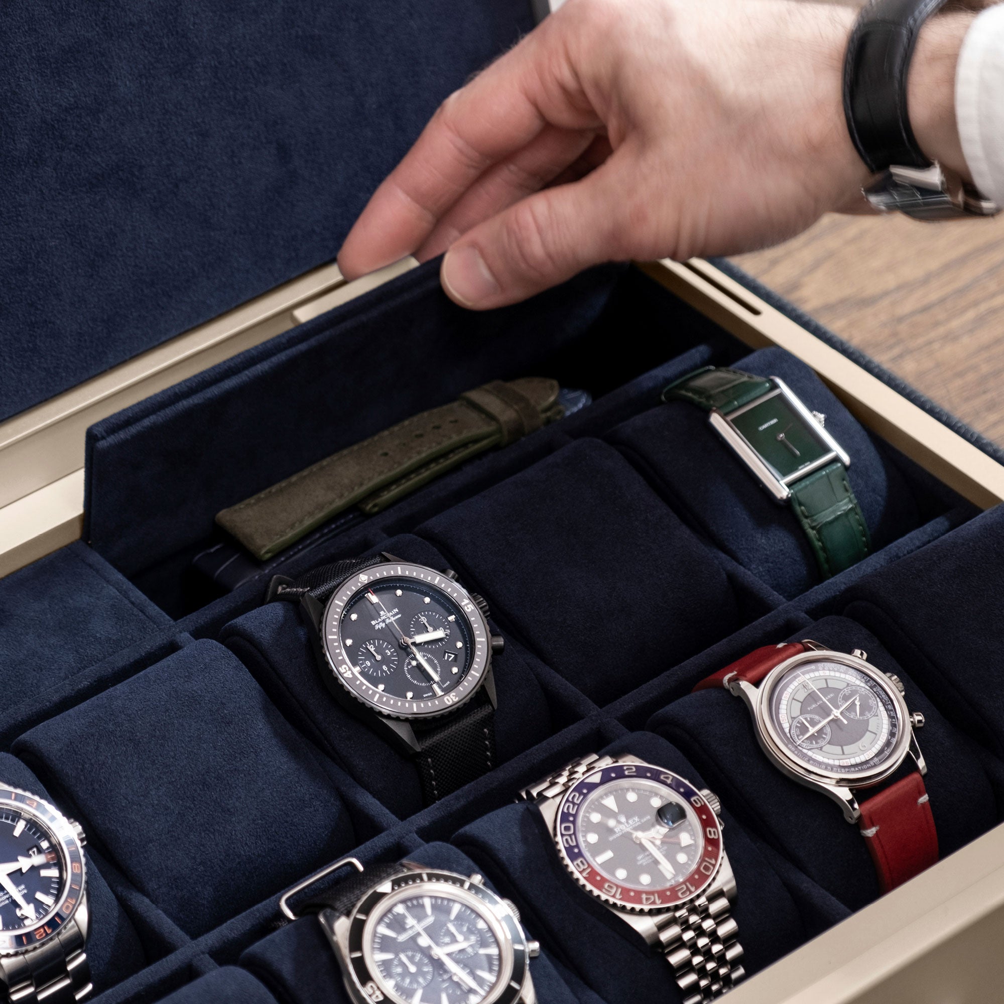 Man opening additional storage compartment of his gold Spence 12 Watch box holding his collection of luxury watches