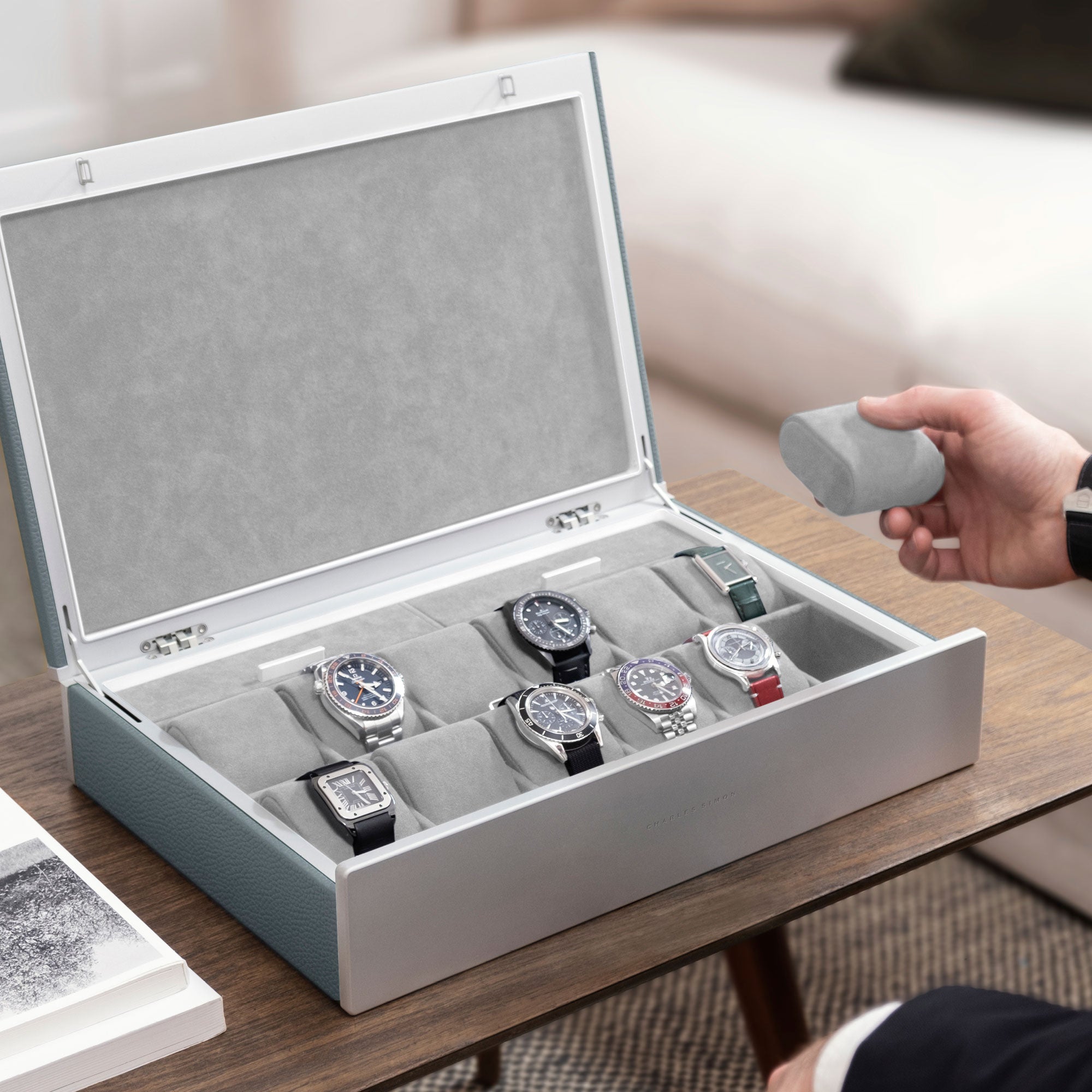 Lifestyle photo of man opening cloud grey leather Spence 12 Watch box with luxury watch collection of up to 12 watches displayed inside