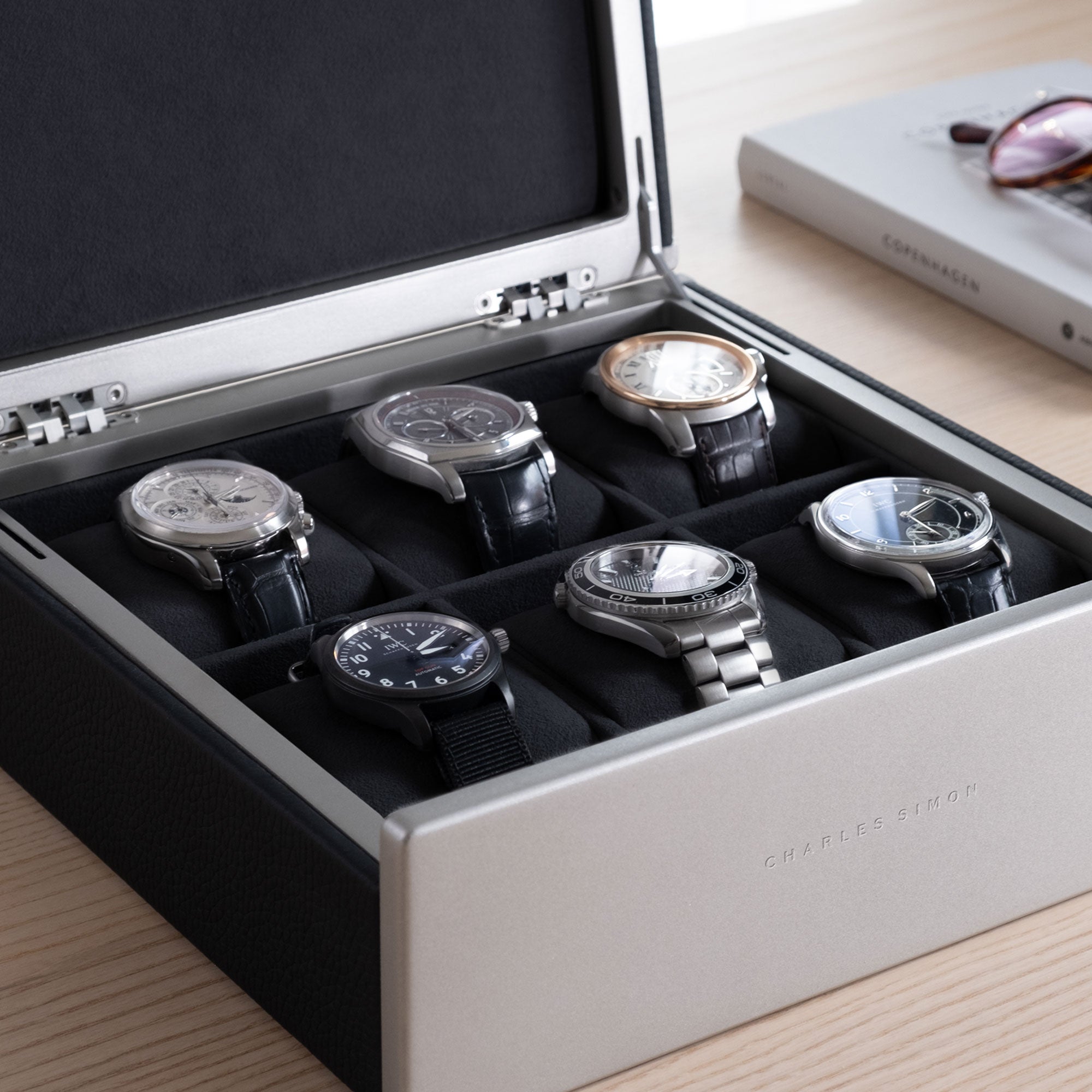 Lifestyle shot of luxury watches in Spence watch box for 6 watches. Made from black Alcantara interior and black leather