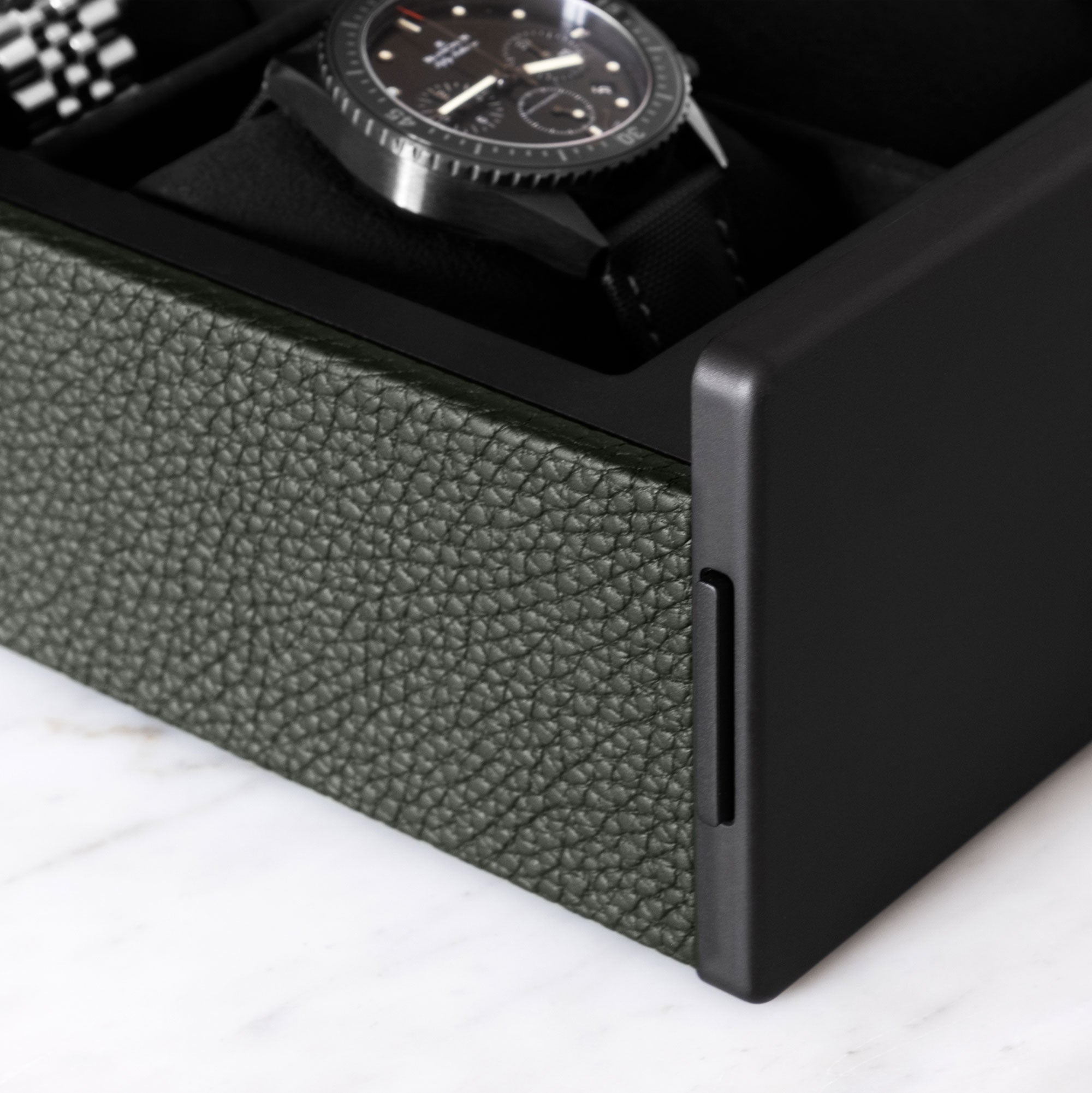 Detail shot of khaki leather and carbon fiber and anodized aluminum of the luxury watch box by Charles Simon