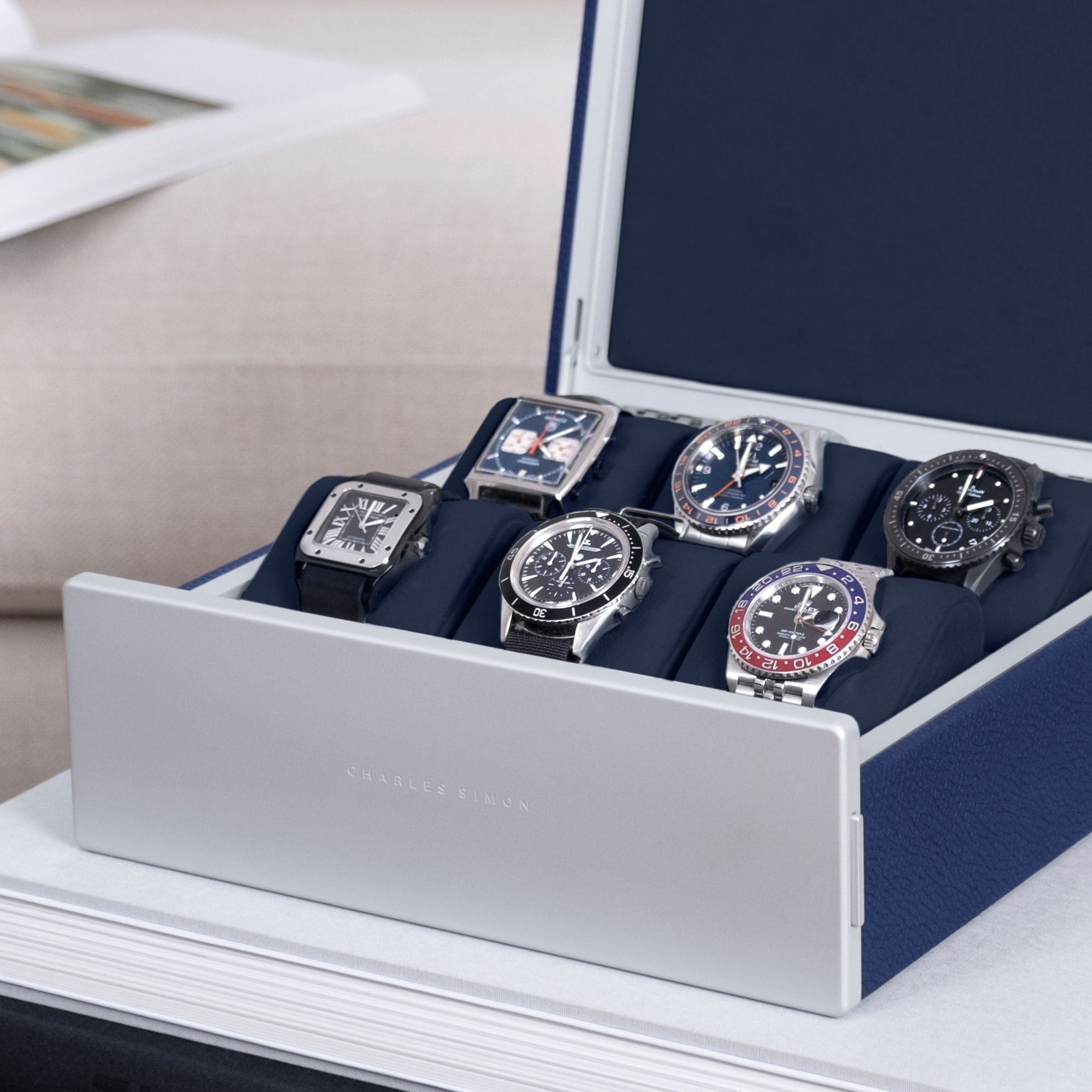 Detail photo of watch collection of six watches, including Cartier, Rolex, Tagheuer, Omega and Jaeger LeCoultre displayed in Spence Watch box in sapphire leather