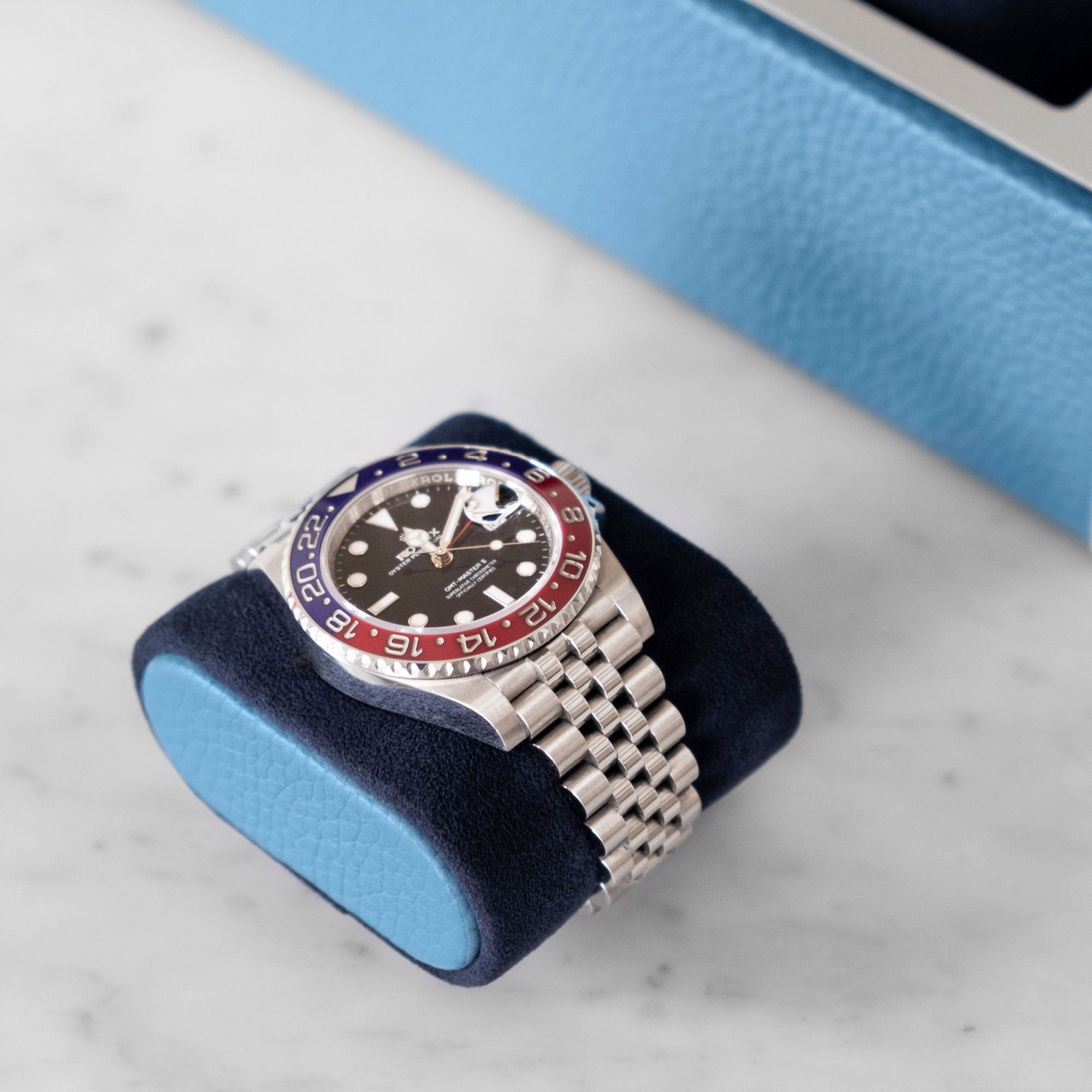 Rolex GMT Pepsi placed on Alcantara cushion with sky blue leather cushion sides 