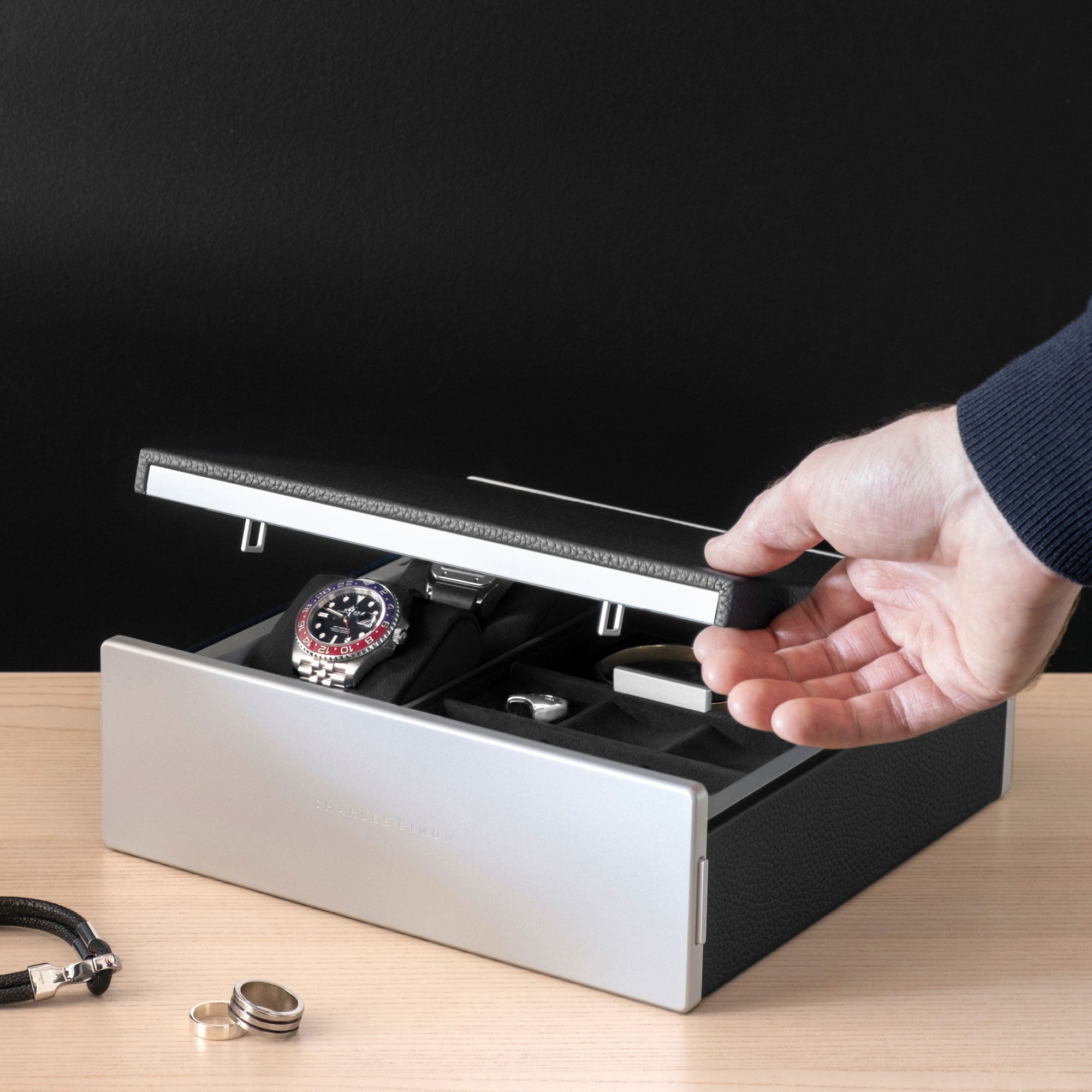 Man opening Taylor 2 Watch box holding timepiece and jewelry collection. The luxury watch box is displayed in a modern home.