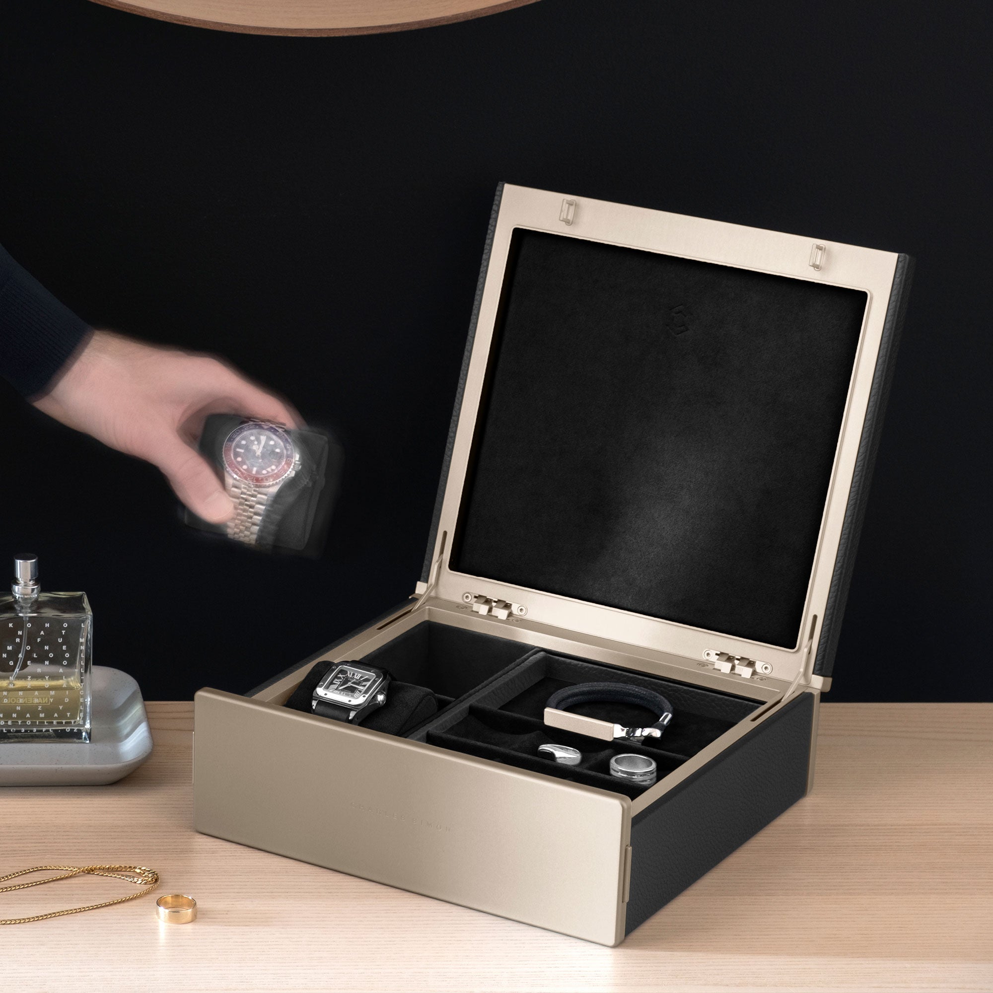 Lifestyle photo of black Taylor 2 gold watch and jewelry box for an entire collection of watches and jewelry.