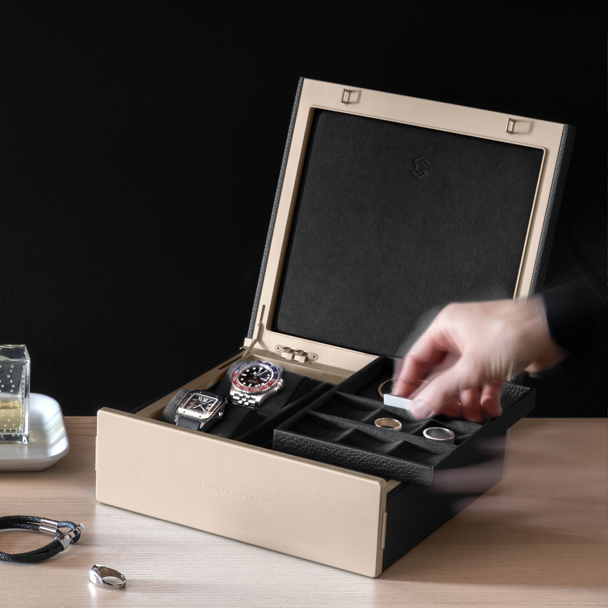 Man taking jewelry tray from the gold Taylor 2 Watch and Jewelry box in black leather and notte interior. Stores and organizes your jewelry and timepieces. Made in Canada.