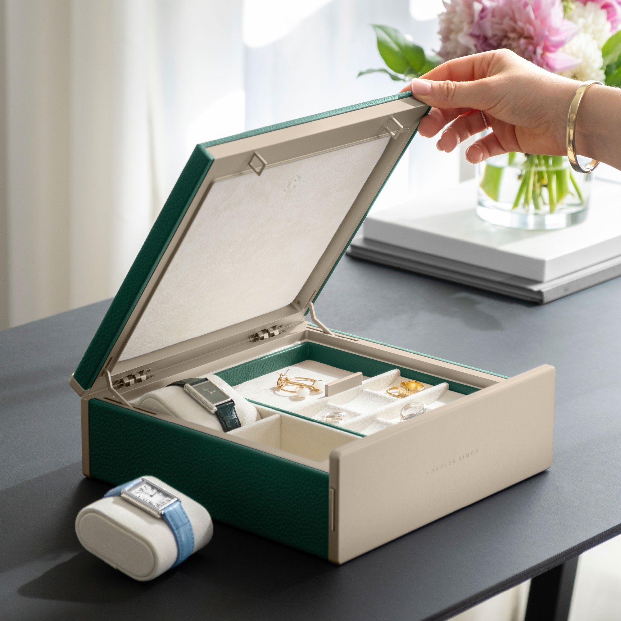 Woman opening her jewelry collection stored and organized in the gold and emerald Taylor 2 Watch box.