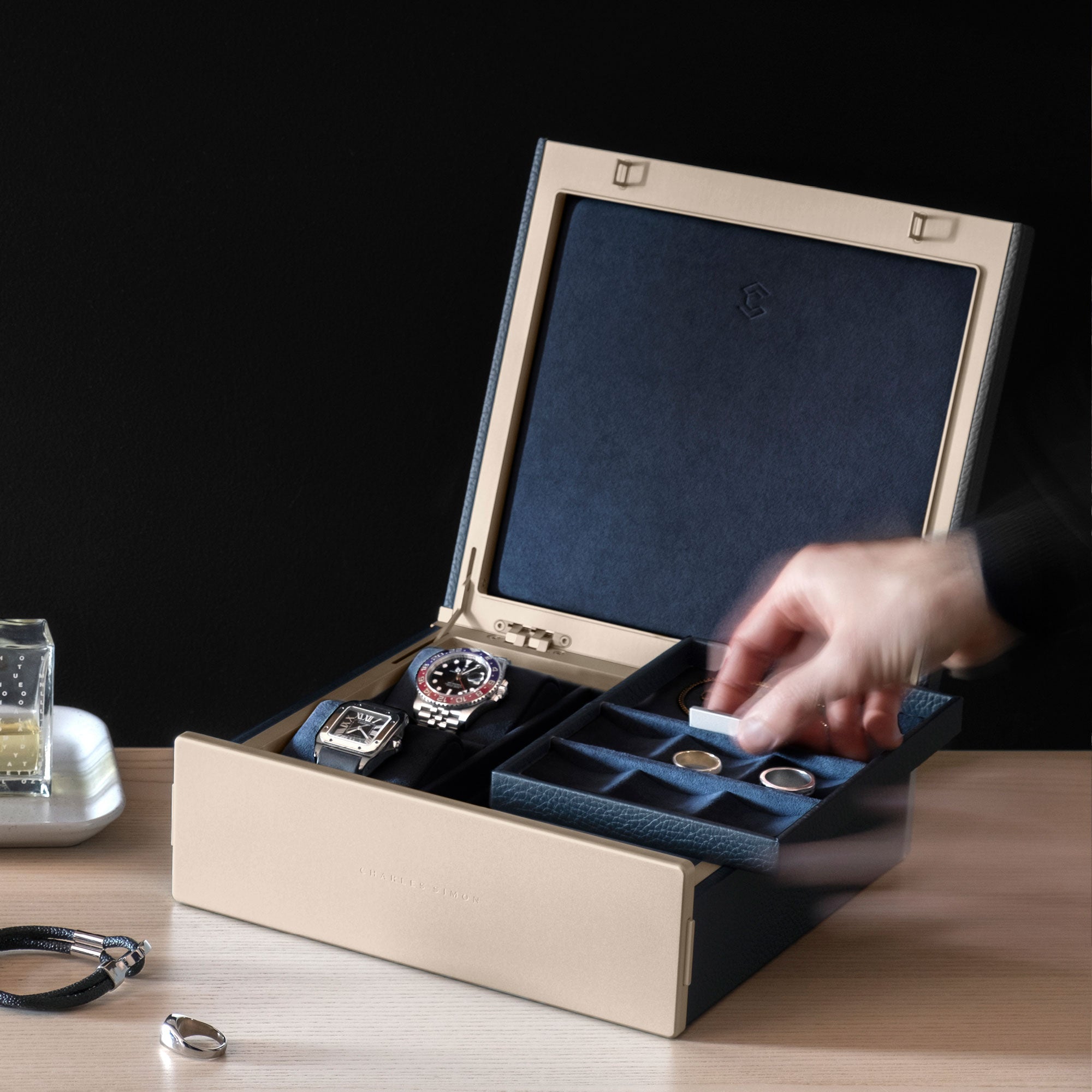 Man taking jewelry tray from the gold Taylor 2 Watch and Jewelry box in marine leather and deep blue interior. Stores and organizes your jewelry and timepieces. Made in Canada.