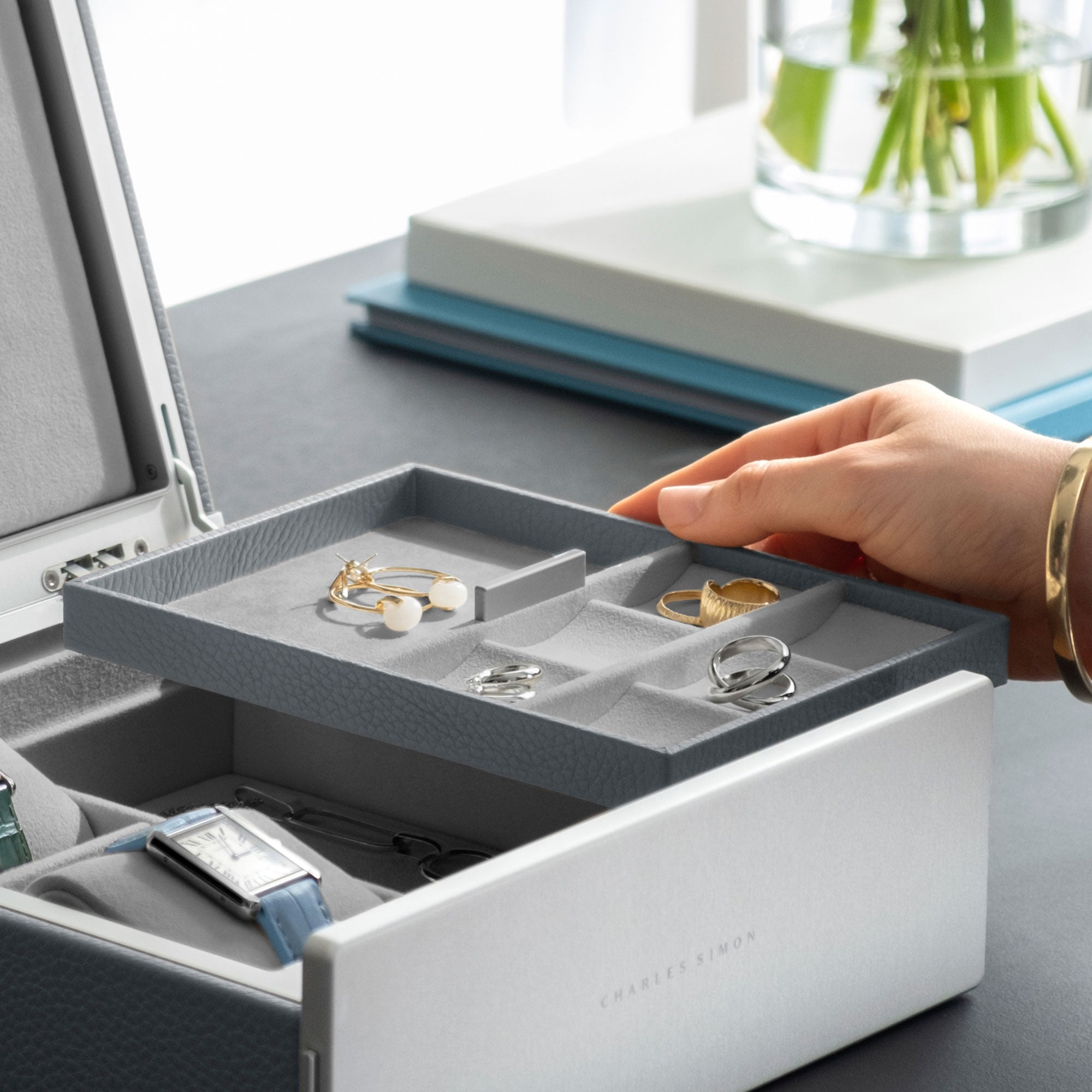 Woman holding jewelry tray of the Taylor 2 Watch and Jewelry box keeping silver and gold jewelry including rings and earrings as well as two Cartier watches