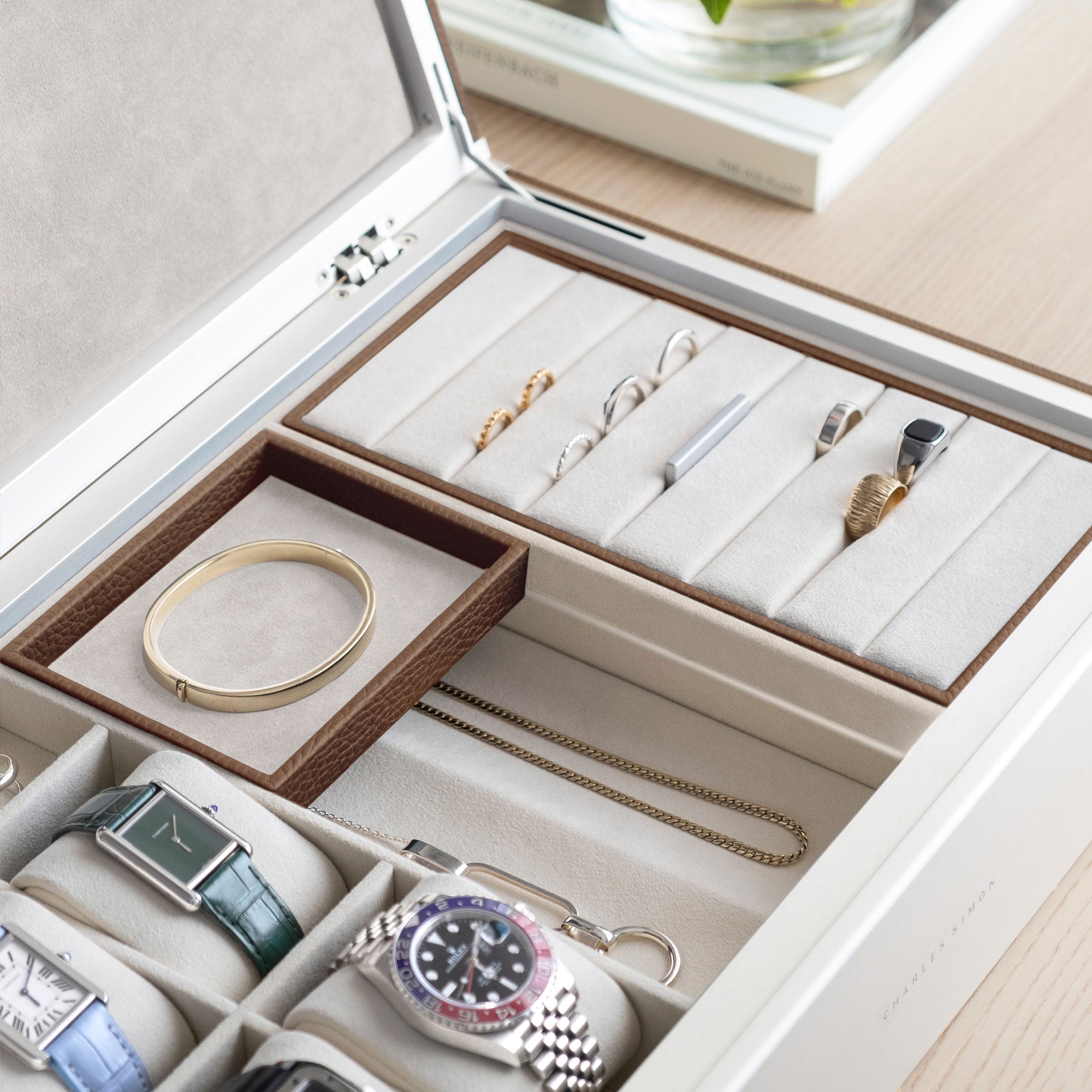 Detail photo of jewelry storage compartments and watch cushions of the Taylor 4 Watch and Jewelry box in tan leather and eggshell interior. 