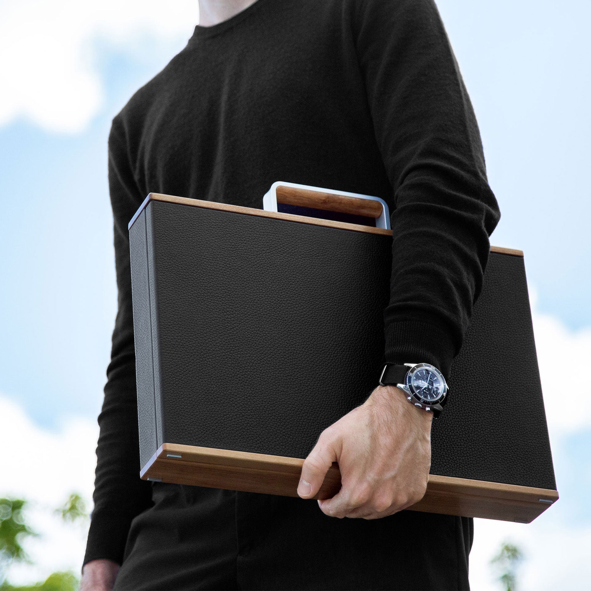 Lifestyle shot of man wearing luxury watch holding elegant Mackenzie watch briefcase with wood accents