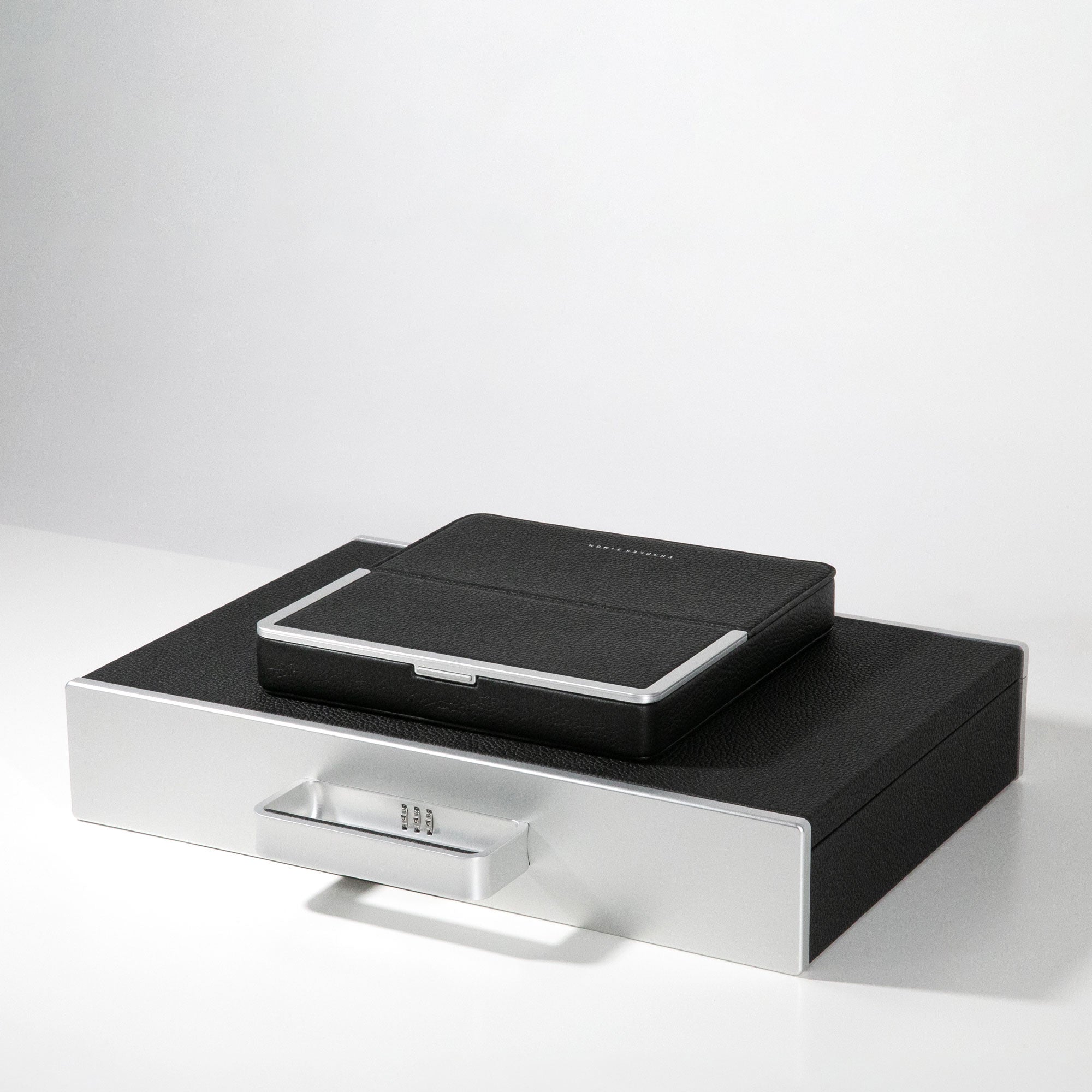 Black leather travel wallet lying on minimalist black briefcase